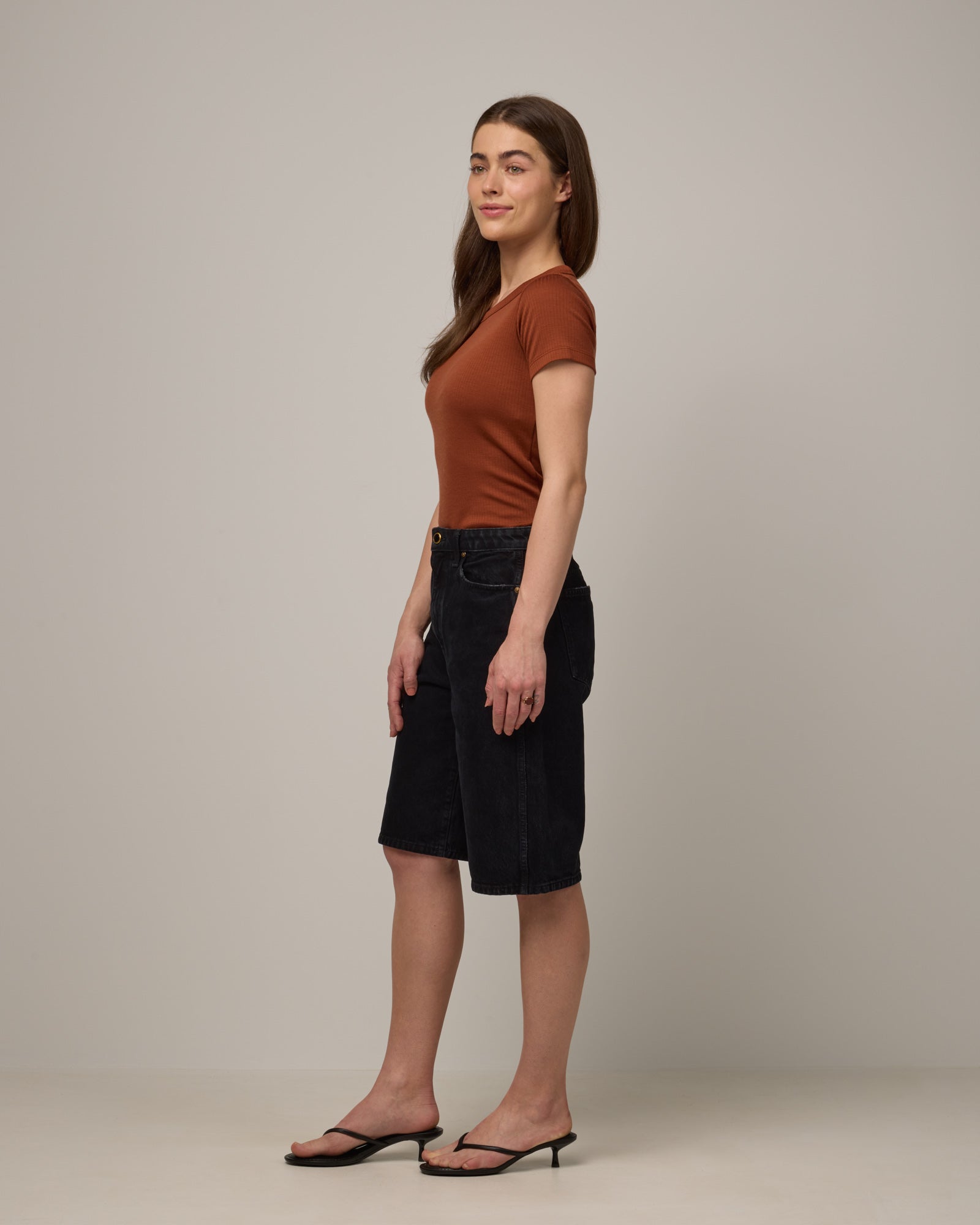 Model wearing Taylor Ribbed Tee in Cinnamon, a reddish-brown rust color. Taylor Ribbed Tee is a merino wool short sleeve, crew neck tee available in sizes XS-3X.