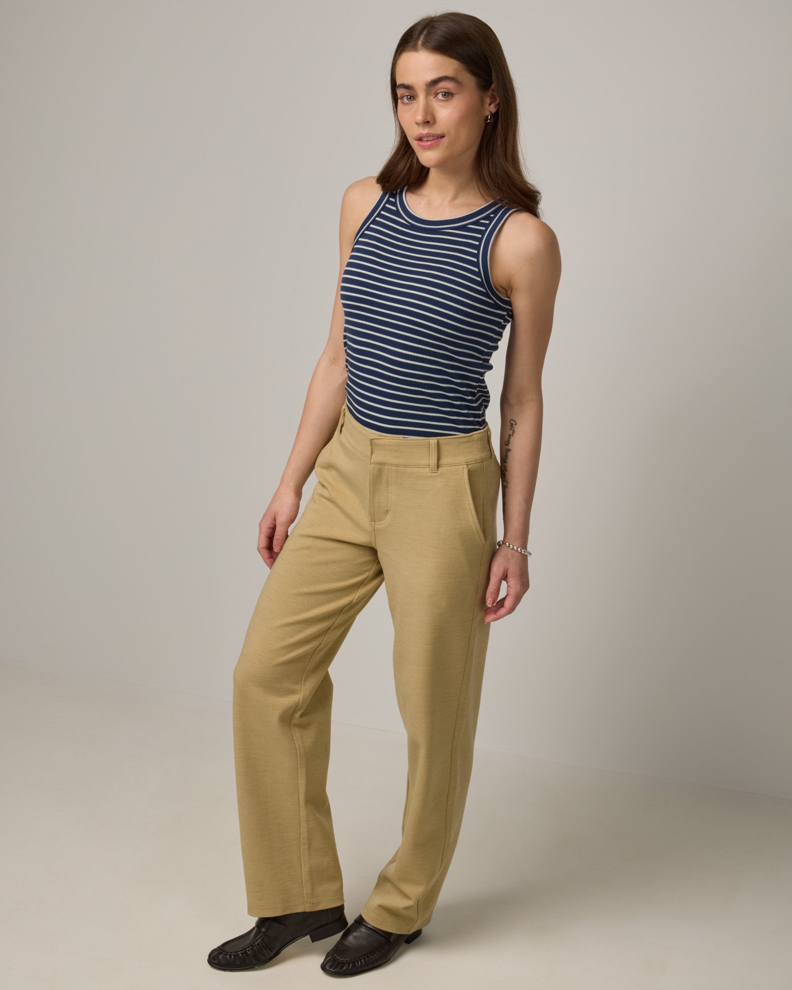 Model wearing Lily Ribbed Tee in Marine Blue & Natural White Stripe. Lily Ribbed Tee is a merino wool sleeveless, crew neck tank available in sizes XS-3X. 