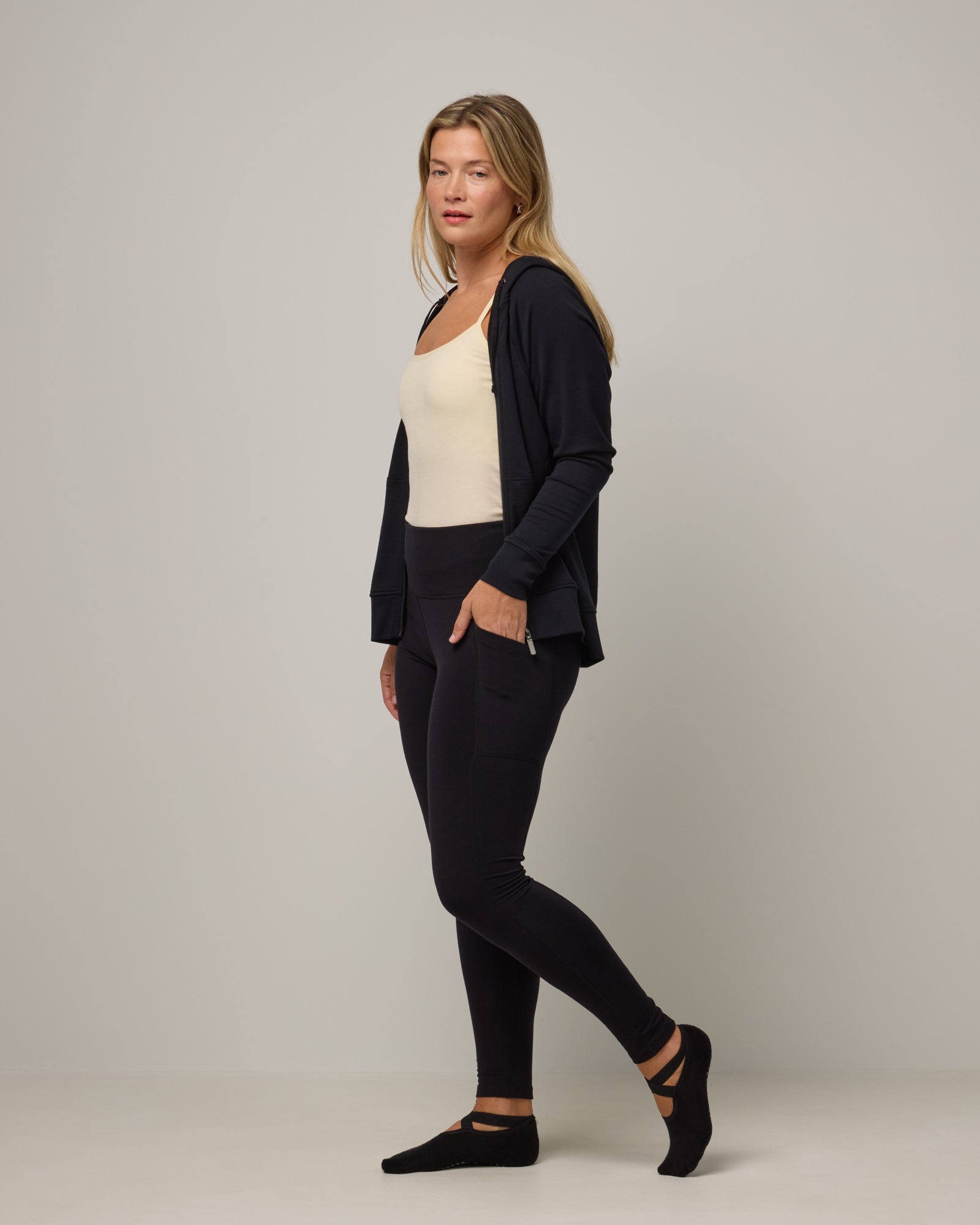 Model wearing Summit Pocket Legging in Black. Summit Pocket Legging is a merino wool legging with pockets available in sizes XS-3X Regular, S-XXL Long.