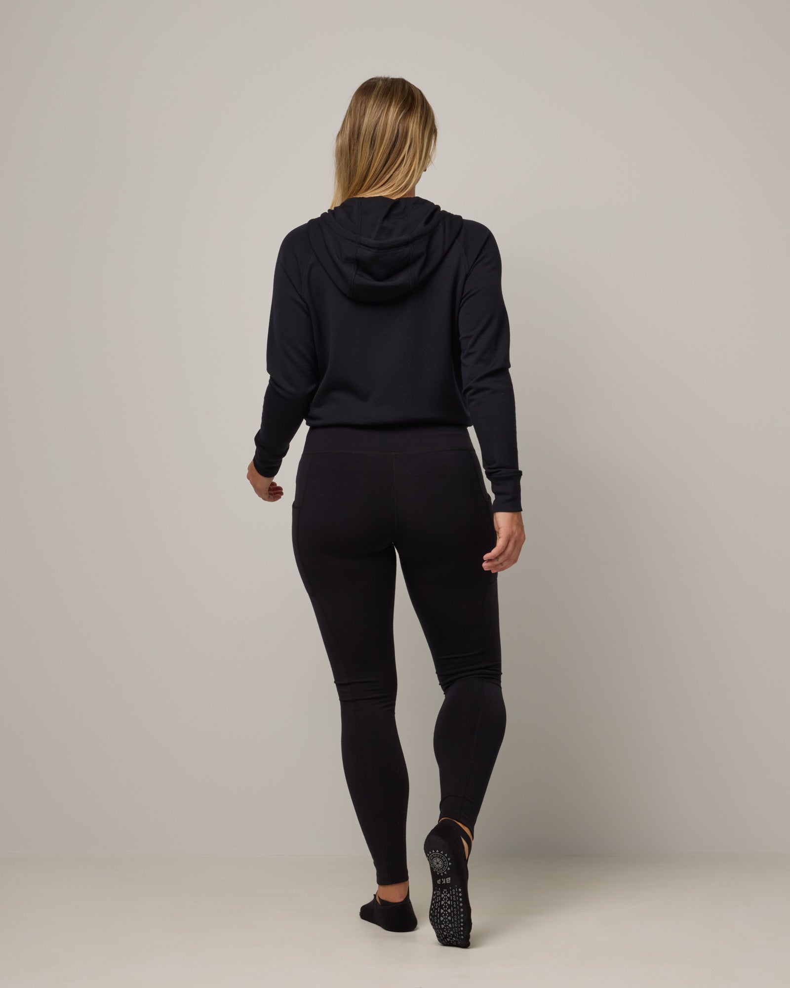 Model wearing Summit Pocket Legging in Black. Summit Pocket Legging is a merino wool legging with pockets available in sizes XS-3X Regular, S-XXL Long.