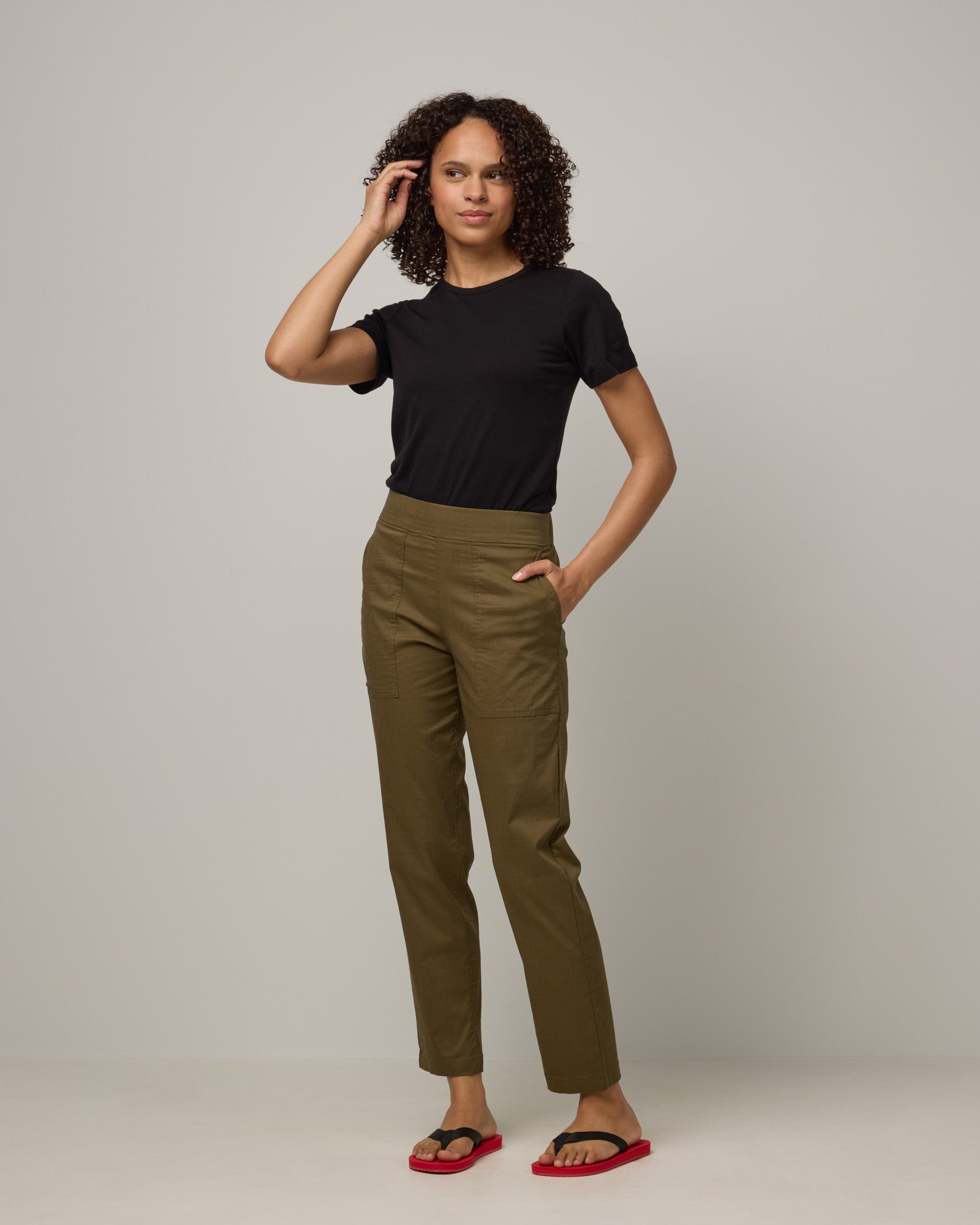 Model wearing Canyon Straight Leg Pant in Olive. Canyon Straight Leg Pant is a merino wool pant with pockets available in sizes XS-3X Regular and XS-XXL Long.