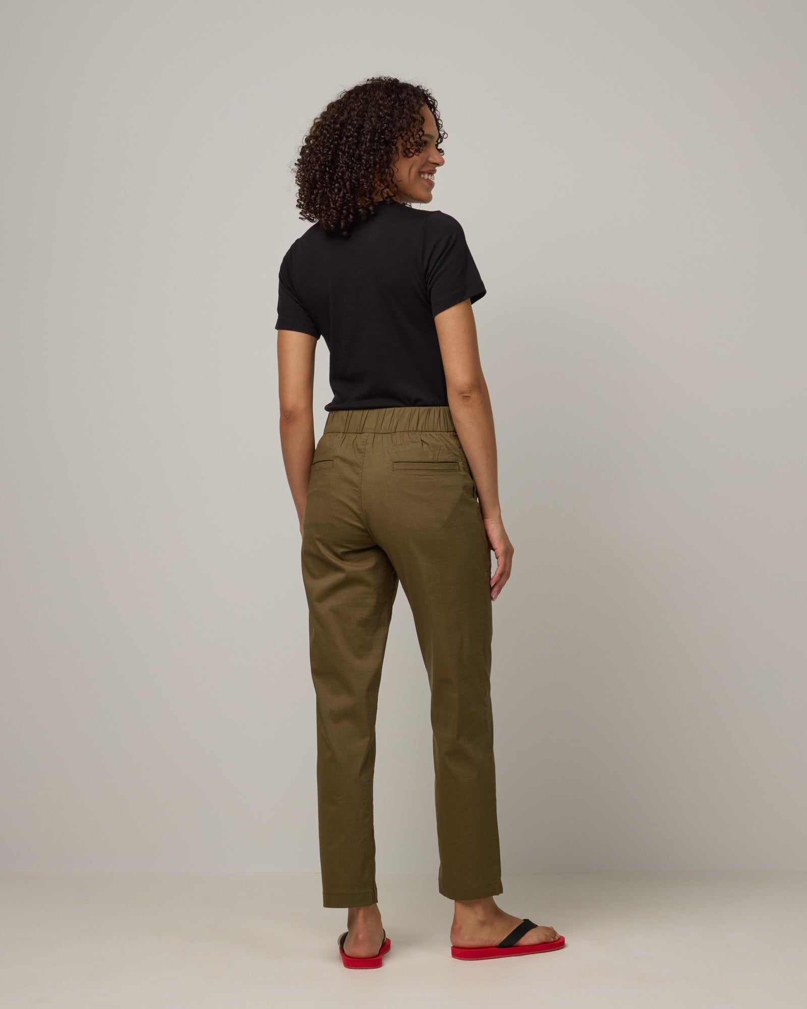 Model wearing Canyon Straight Leg Pant in Olive. Canyon Straight Leg Pant is a merino wool pant with pockets available in sizes XS-3X Regular and XS-XXL Long.