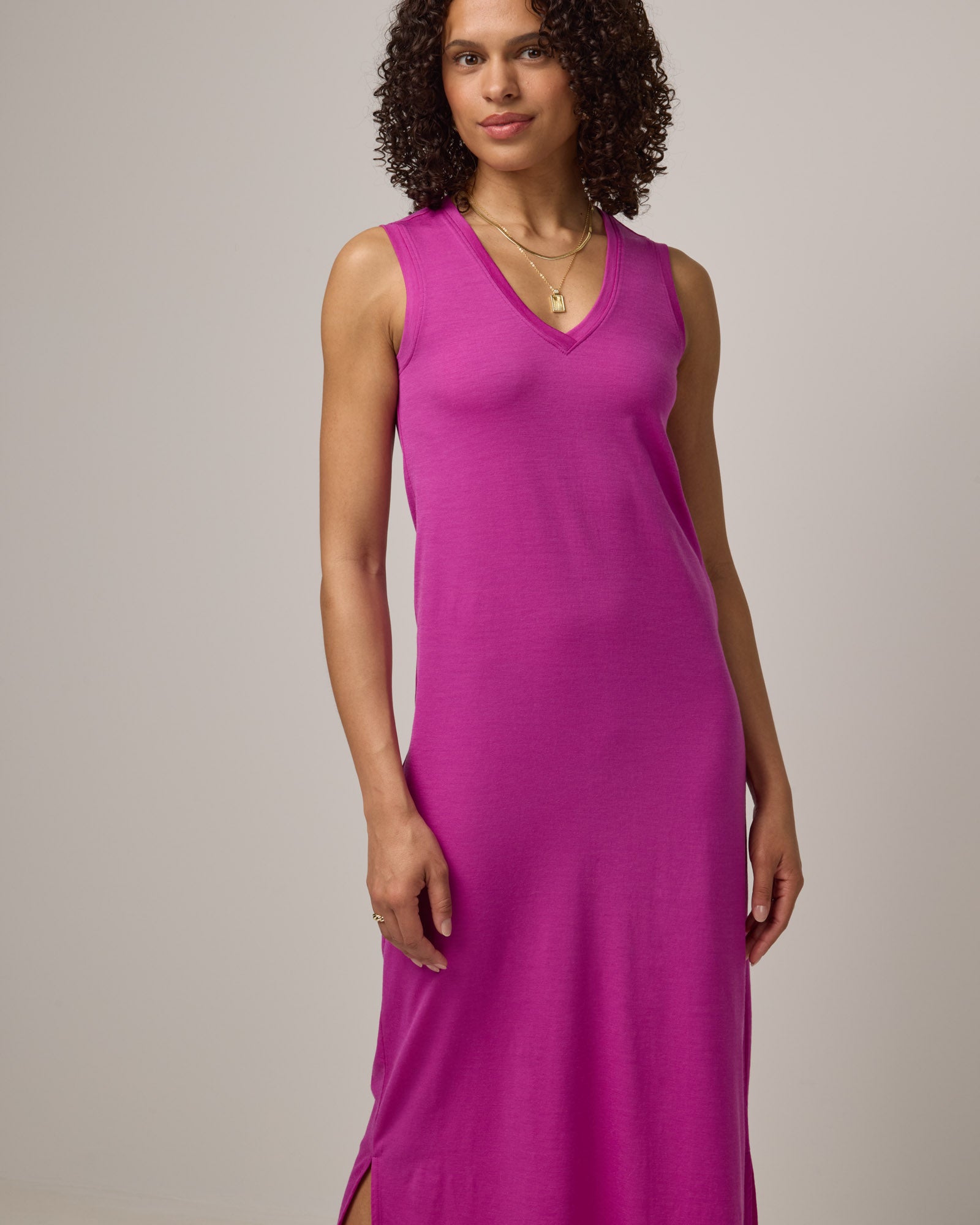 Model wearing Milena Shift Dress in Petunia, a bright fuchsia pink-purple color. Milena Shift Dress is a merino wool sleeveless, v-neck, midi shift dress available in sizes XS-3X regular, XS-XL petite.