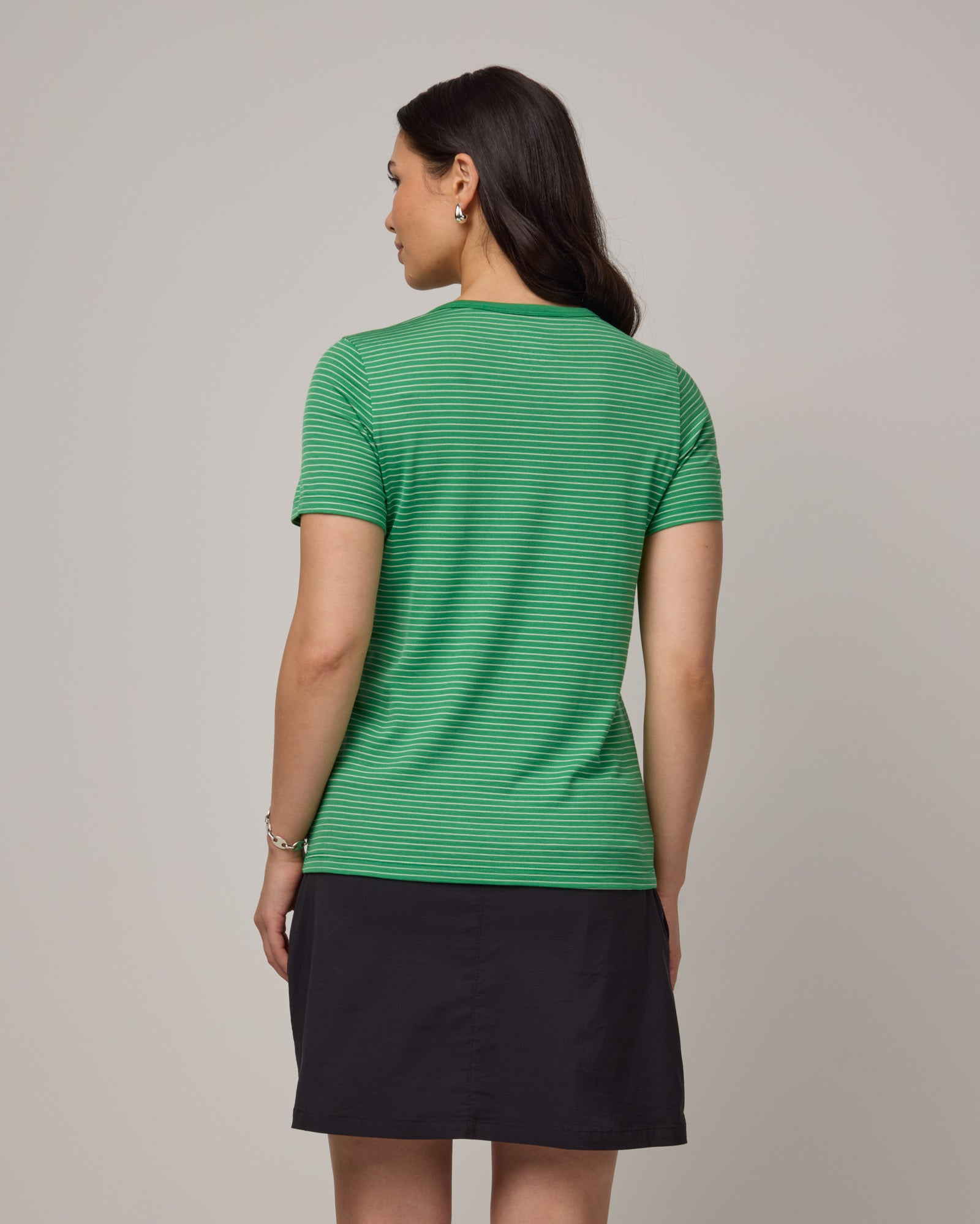 Model wearing Cara Signature Fitted Tee in Verde & Natural White Stripe. Cara Signature Fitted Tee is a merino wool short sleeve, crew neck, slim fit tee available in sizes XS-3X.