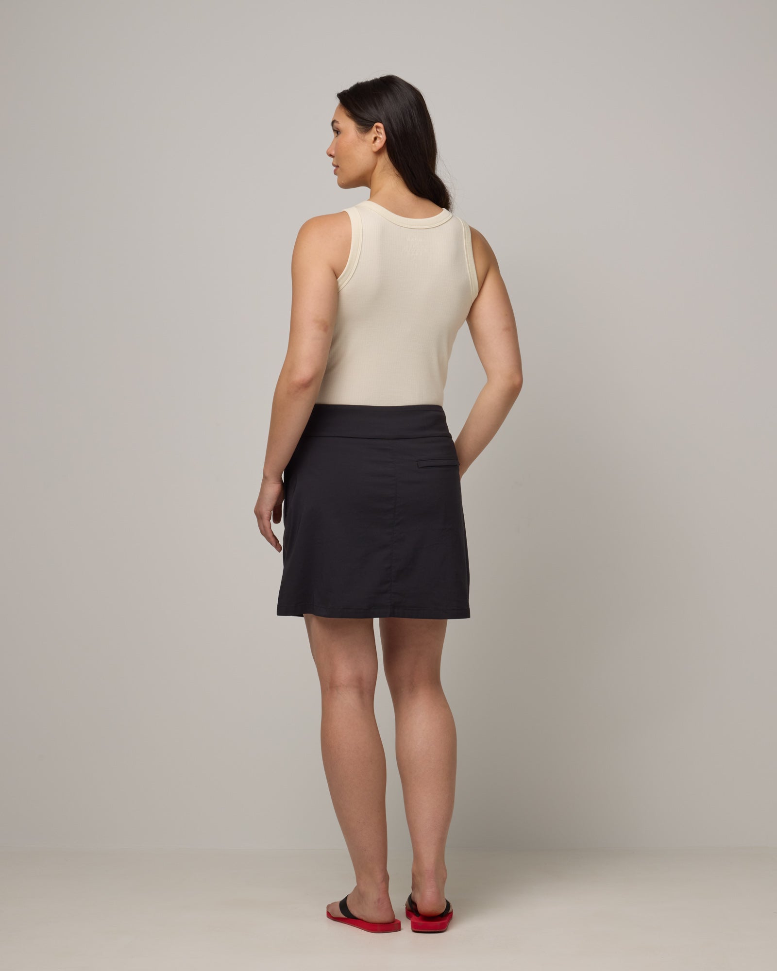 Model wearing Adventure Skort in Black. Adventure Skort is a merino wool above-knee length skort with pockets available in sizes XS-XXL.