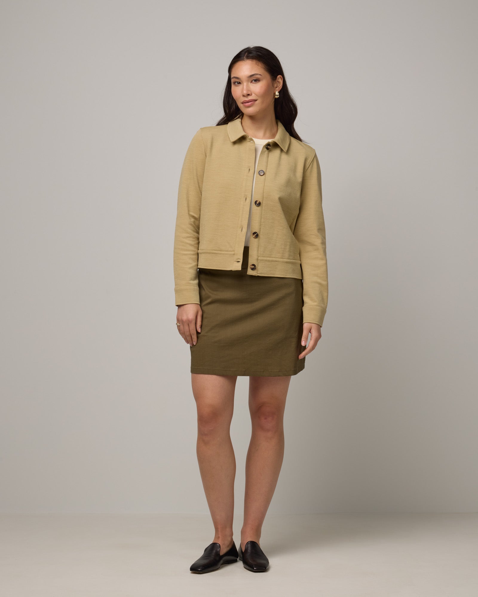 Model wearing Adventure Skort in Olive. Adventure Skort is a merino wool above-knee length skort with pockets available in sizes XS-XXL.