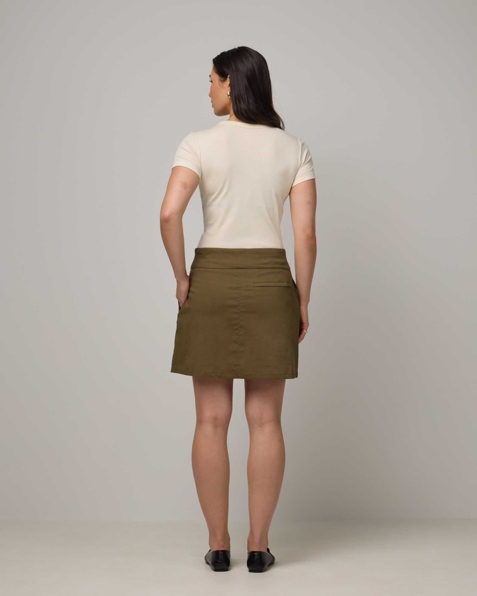 Model wearing Adventure Skort in Olive. Adventure Skort is a merino wool above-knee length skort with pockets available in sizes XS-XXL.