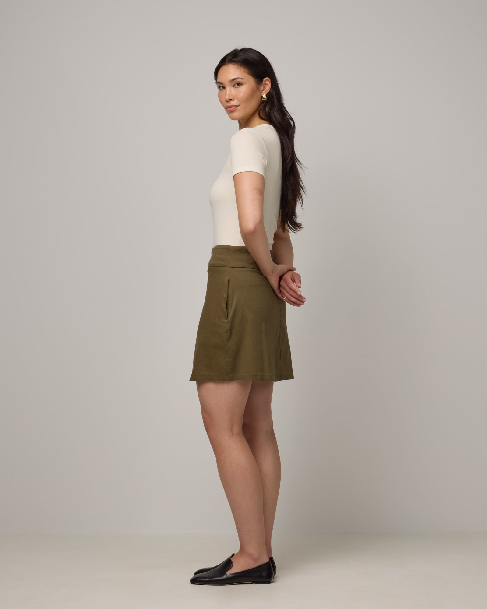 Model wearing Adventure Skort in Olive. Adventure Skort is a merino wool above-knee length skort with pockets available in sizes XS-XXL.