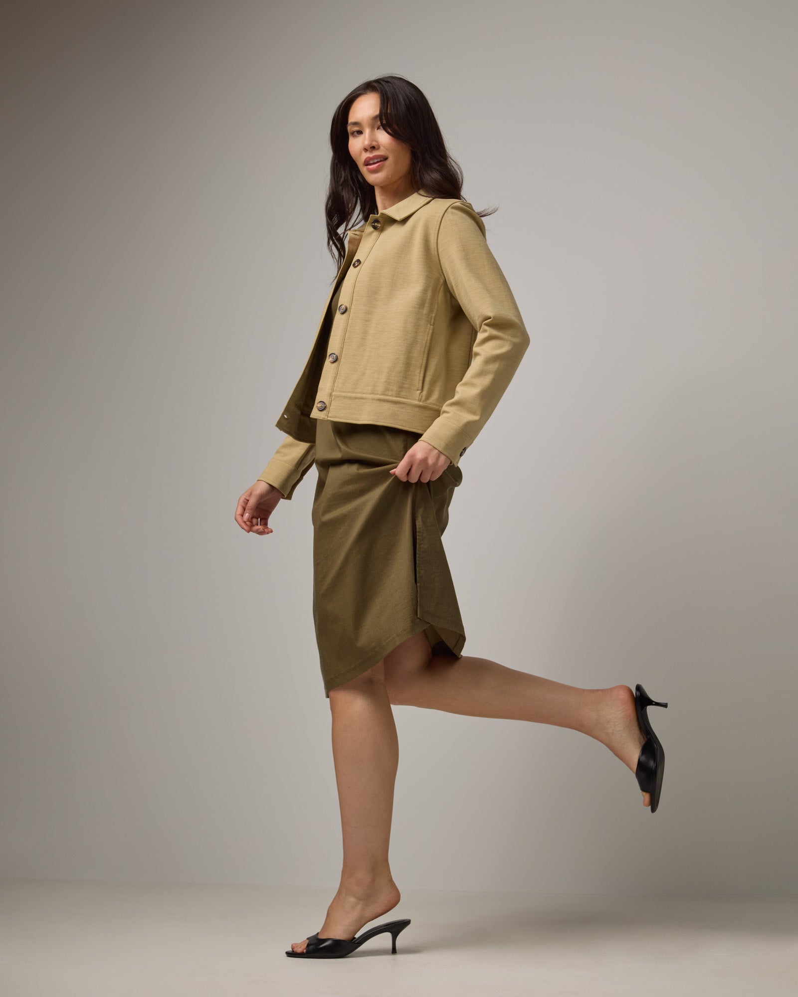 Model wearing Acadia Racerback Dress in Olive. Acadia Racerback Dress is a merino wool sleeveless, v-neck, midi length fitted dress available in sizes XS-XXL.