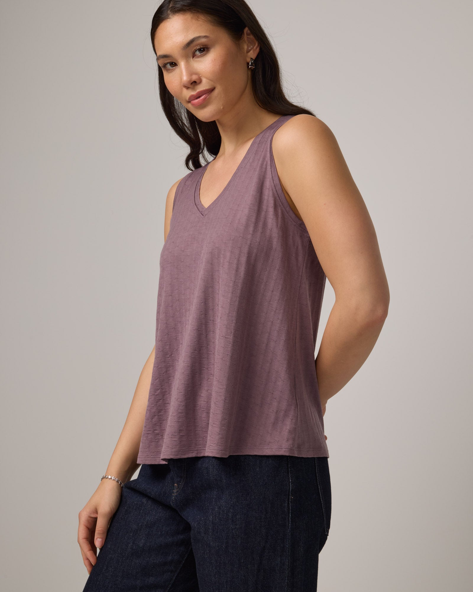 Model wearing Poppy Jacquard Reversible Tank in Lavender, a dusky muted purple color. Poppy Signature Reversible Tank is a merino wool sleeveless, reversible, relaxed fit top available in sizes XS-3X.