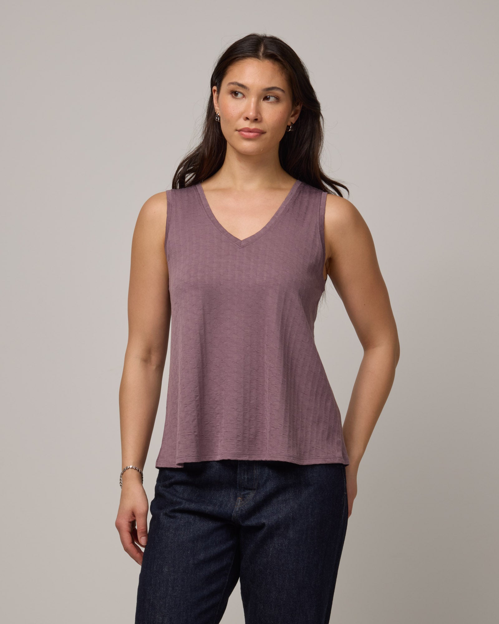 Model wearing Poppy Jacquard Reversible Tank in Lavender, a dusky muted purple color. Poppy Signature Reversible Tank is a merino wool sleeveless, reversible, relaxed fit top available in sizes XS-3X.