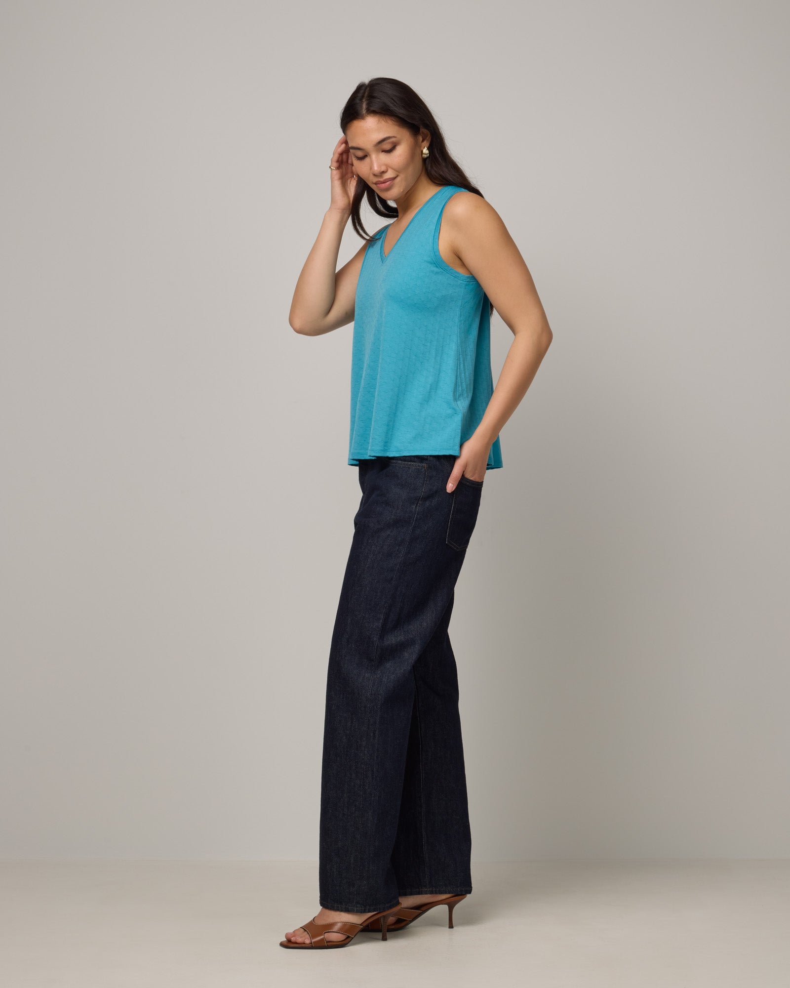 Model wearing Poppy Jacquard Reversible Tank in Sea Blue, a bright sky blue color. Poppy Signature Reversible Tank is a merino wool sleeveless, reversible, relaxed fit top available in sizes XS-3X.
