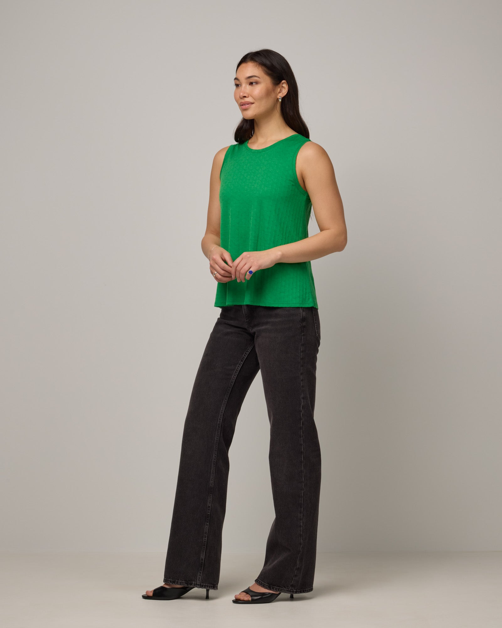 Model wearing Poppy Jacquard Reversible Tank in Verde, a bright Kelly green color. Poppy Signature Reversible Tank is a merino wool sleeveless, reversible, relaxed fit top available in sizes XS-3X.