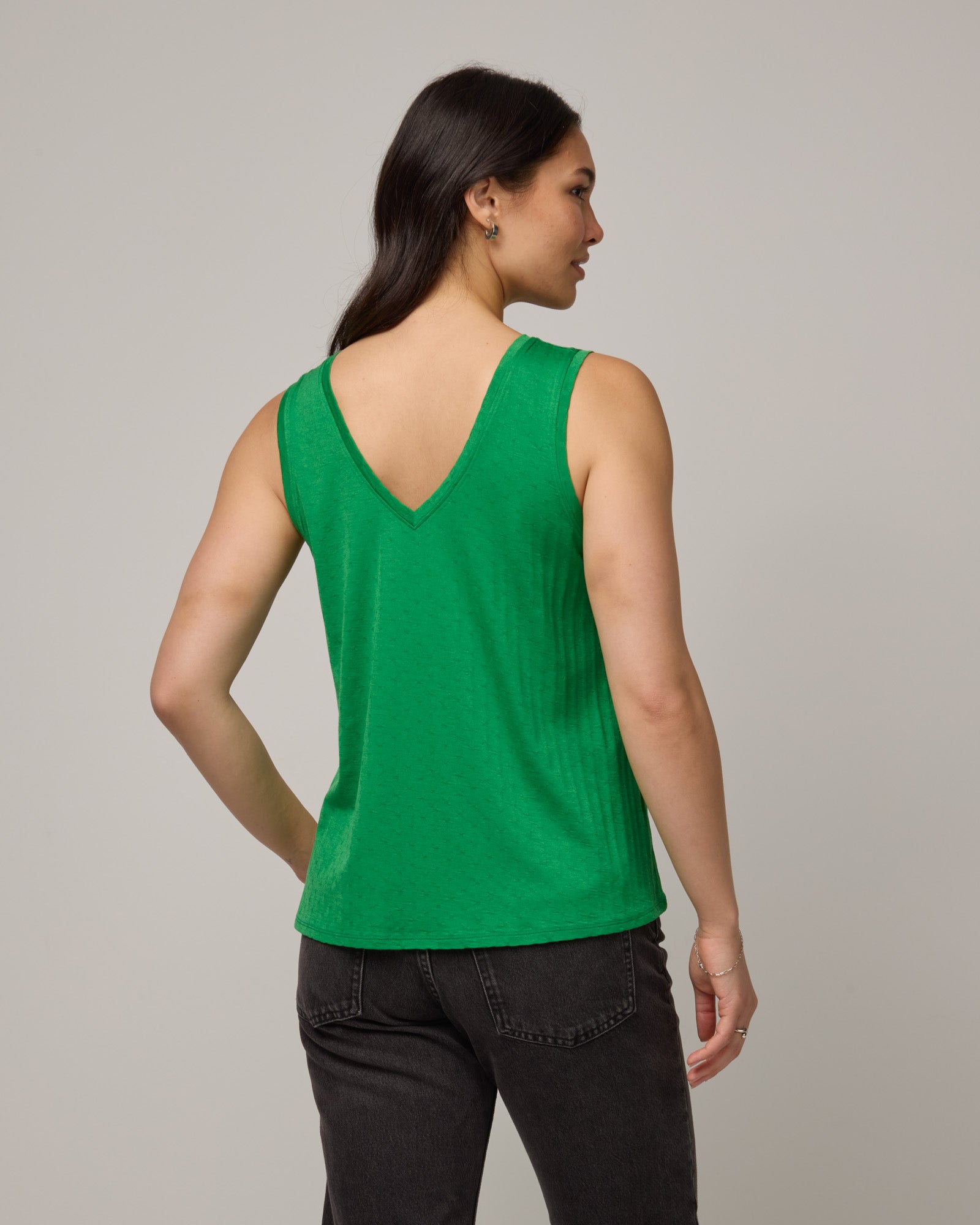 Model wearing Poppy Jacquard Reversible Tank in Verde, a bright Kelly green color. Poppy Signature Reversible Tank is a merino wool sleeveless, reversible, relaxed fit top available in sizes XS-3X.