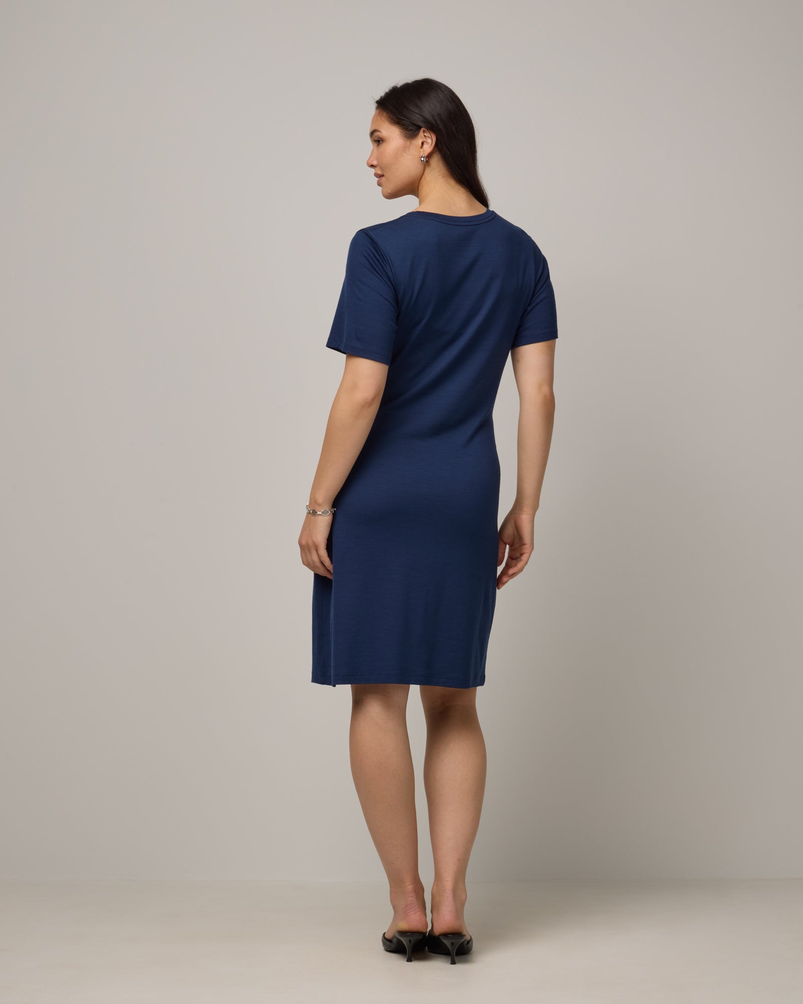 Model wearing Kelly Faux Tie Dress in Marine Blue, a deep royal blue color. Kelly Faux Tie Dress is a merino wool crew neck, short sleeve, knee length shift dress with pockets available in sizes XS-3X. 