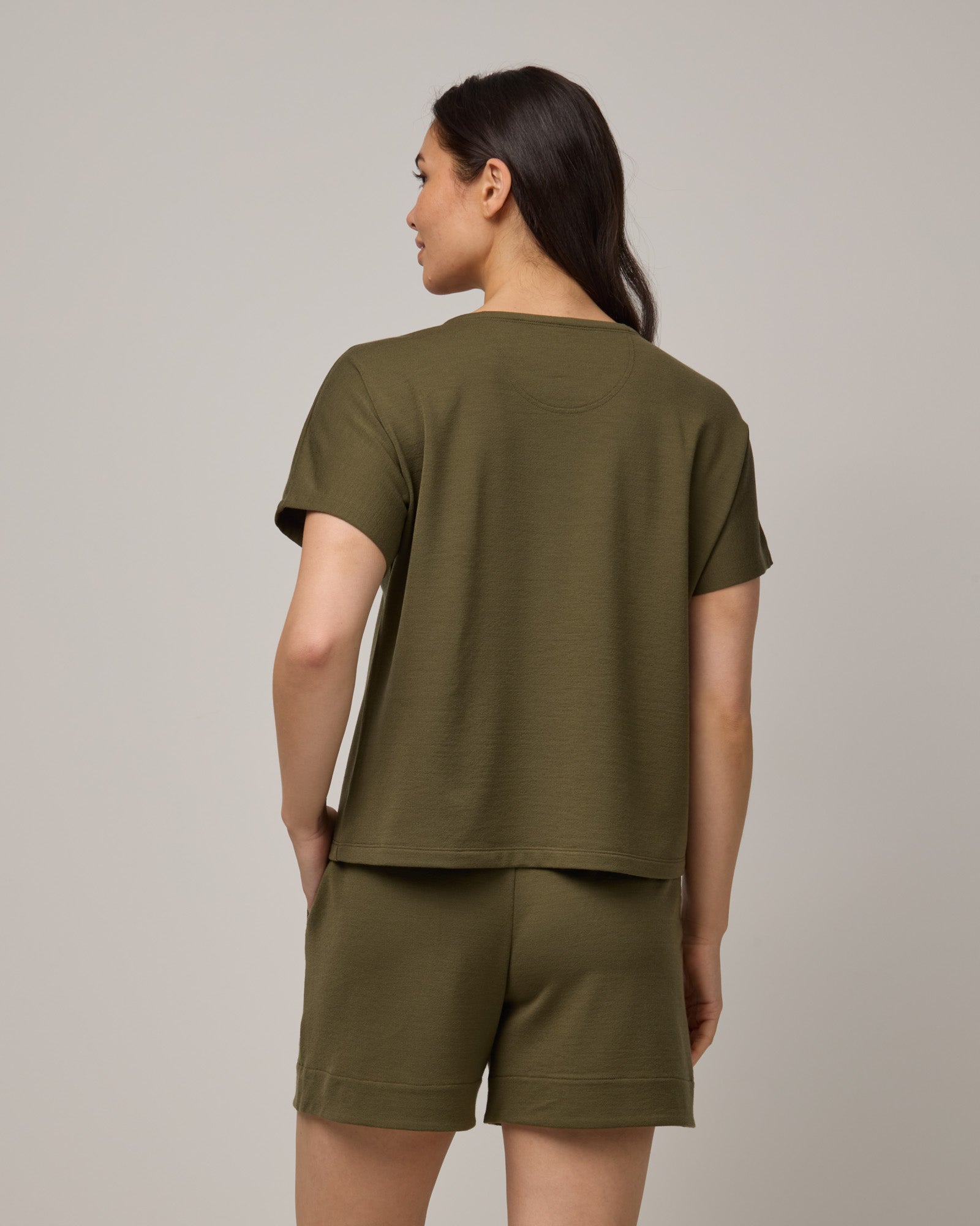 Model wearing Carina Sweatshirt Tee in Olive. Carina Sweatshirt Tee is a merino wool short sleeve, crew neck, relaxed fit boxy tee available in sizes XS-XXL.