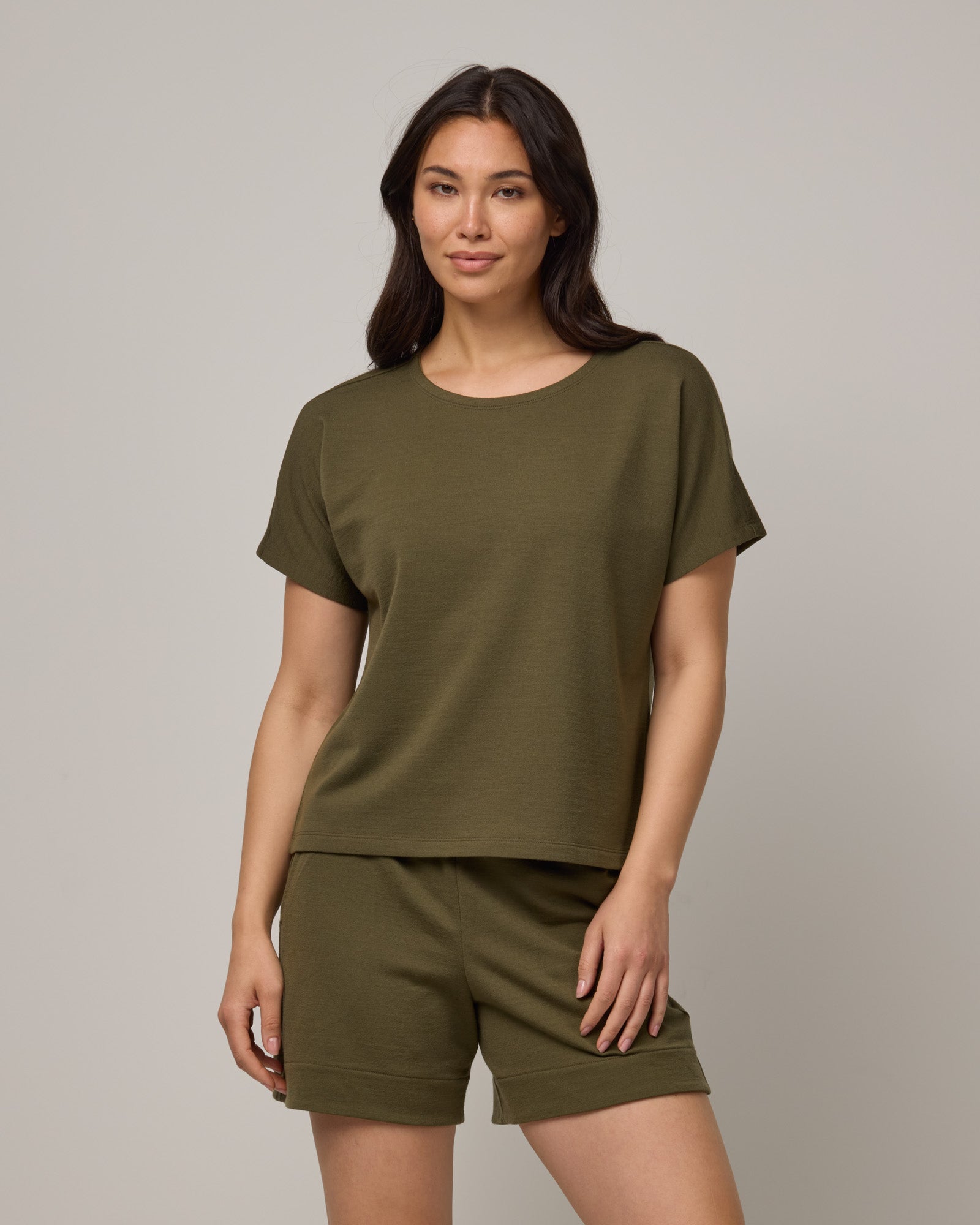 Model wearing Carina Sweatshirt Tee in Olive. Carina Sweatshirt Tee is a merino wool short sleeve, crew neck, relaxed fit boxy tee available in sizes XS-XXL.