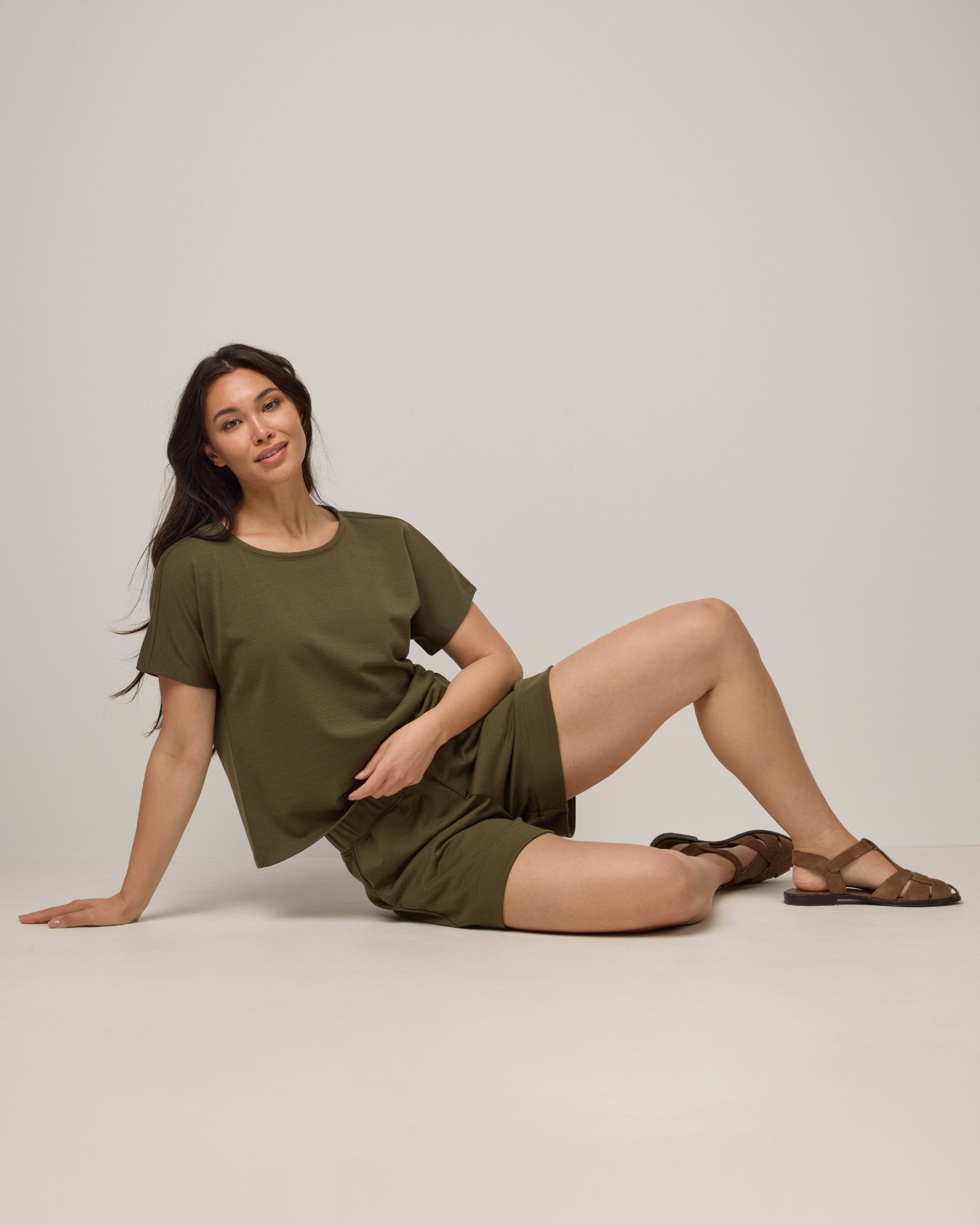Model wearing Carina Sweatshirt Tee in Olive. Carina Sweatshirt Tee is a merino wool short sleeve, crew neck, relaxed fit boxy tee available in sizes XS-XXL.
