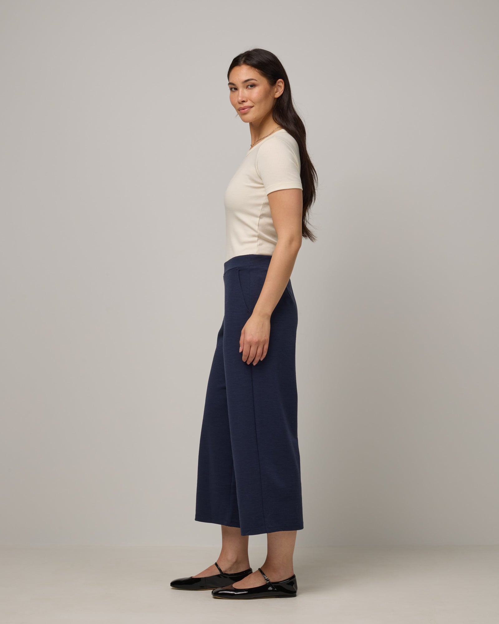 Model wearing Frame Ponte Culotte in Washed Navy. Frame Ponte Culotte is a merino wool pant with pockets available in sizes XS-3X Regular, XS-XL Petite.