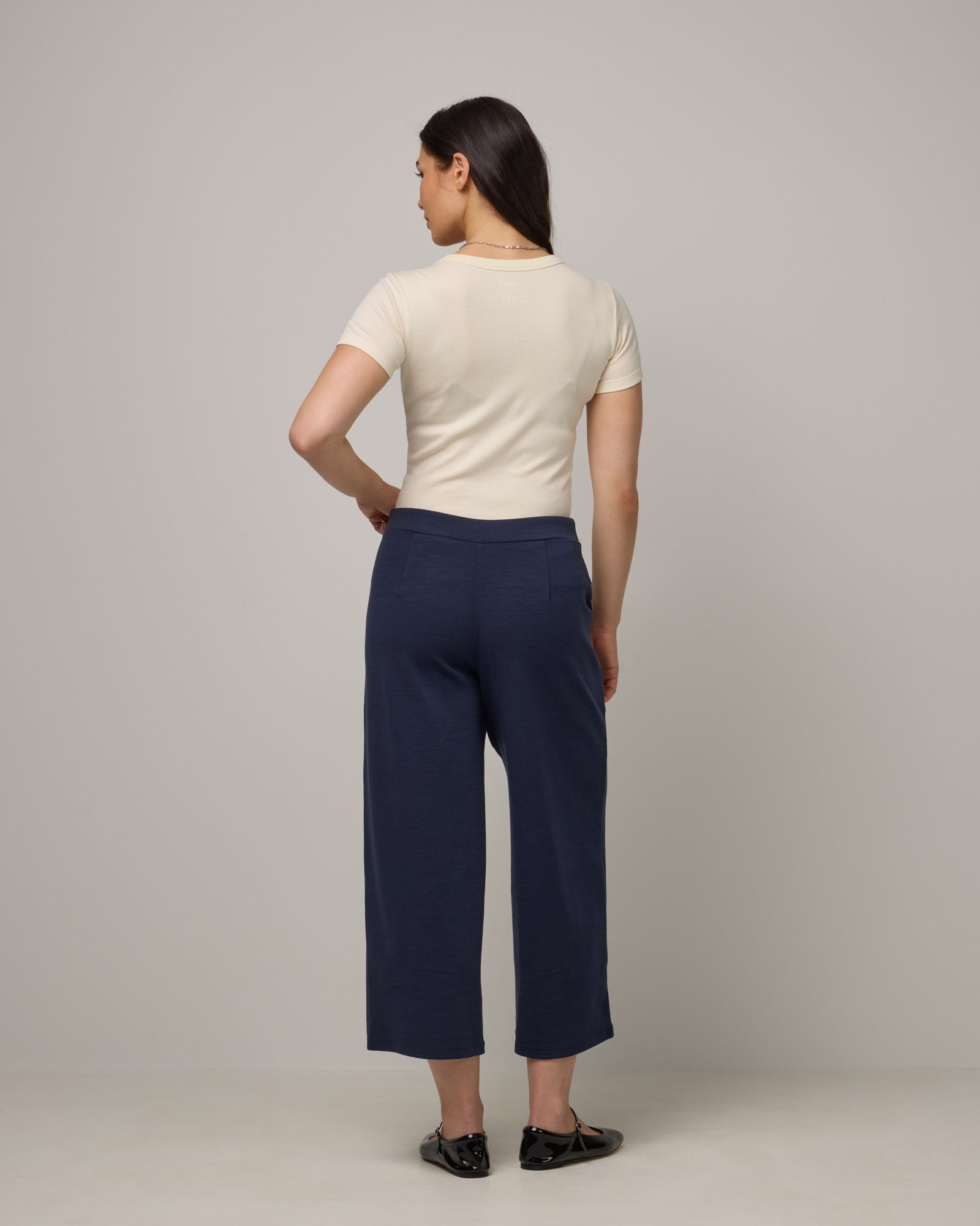 Model wearing Frame Ponte Culotte in Washed Navy. Frame Ponte Culotte is a merino wool pant with pockets available in sizes XS-3X Regular, XS-XL Petite.