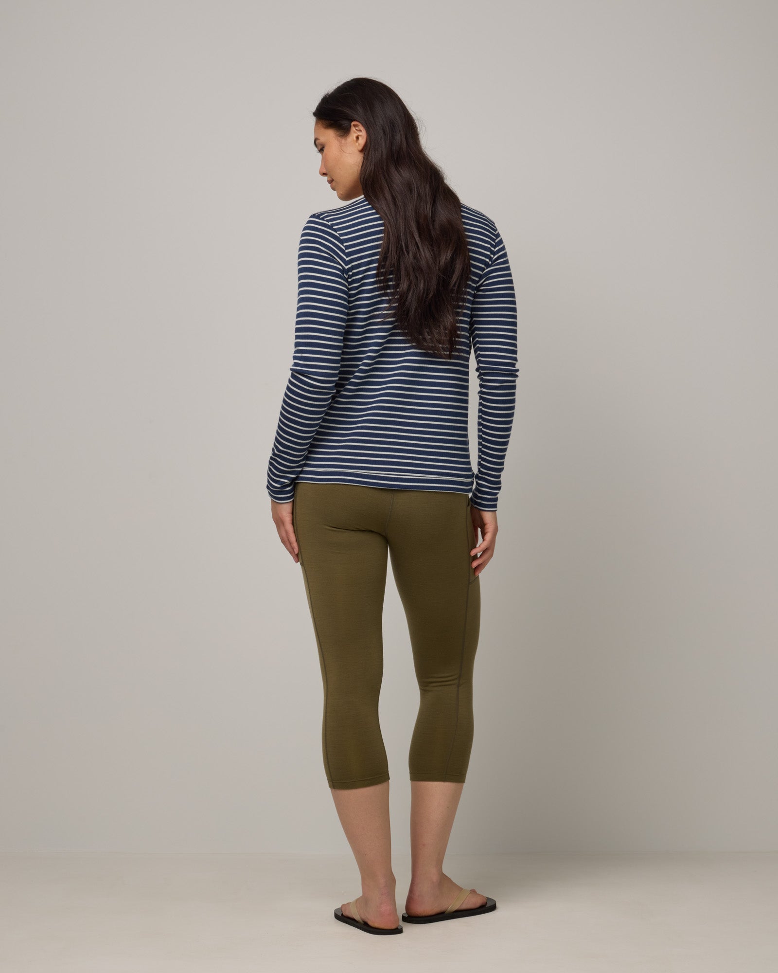 Model wearing Summit Pocket Crop Legging in Olive. Summit Pocket Crop Legging is a merino wool legging with pockets available in sizes XS-3X.