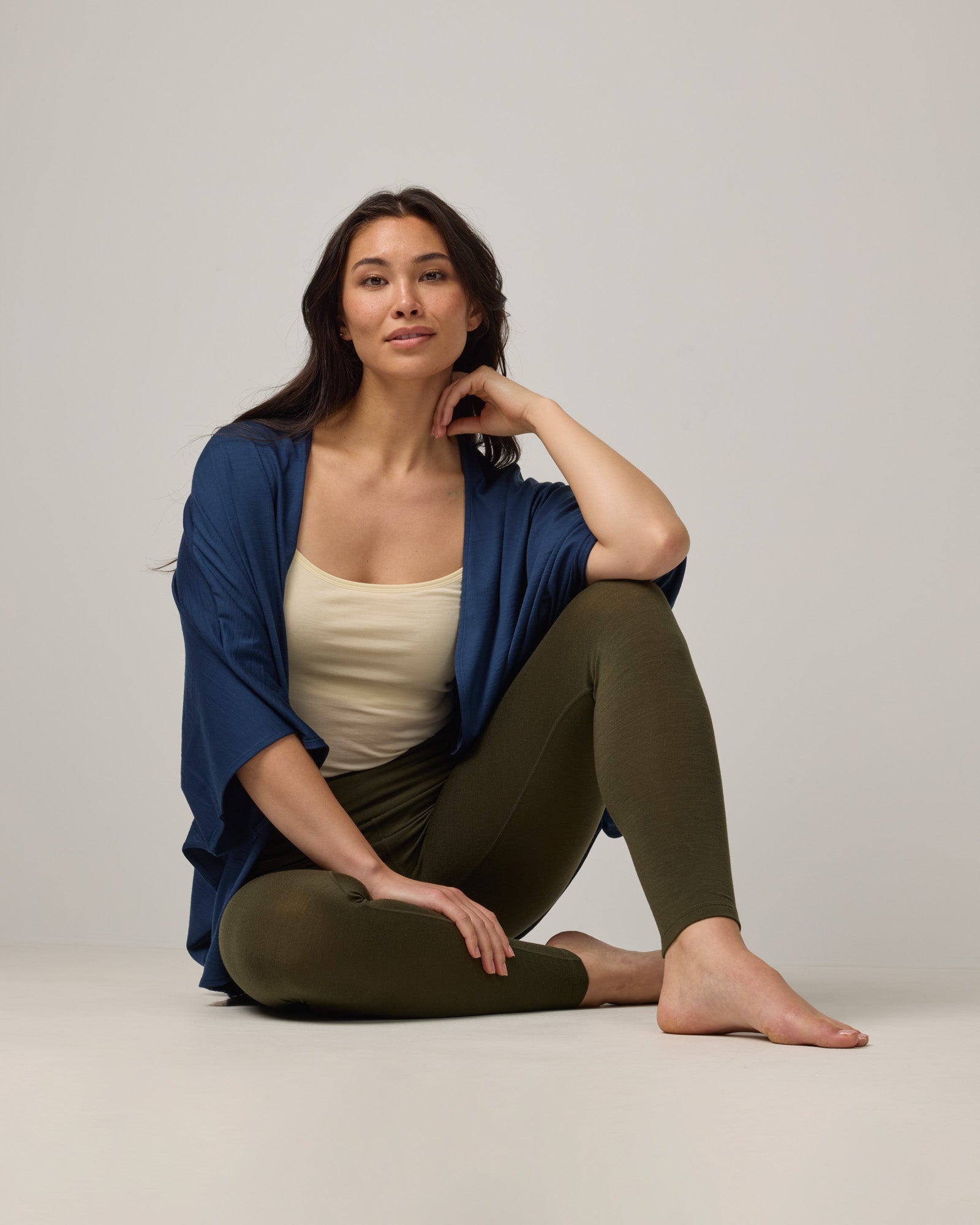 Model wearing Roam Legging in Forest Night, a dark forest green color. Roam Legging is a lightweight merino wool legging with pockets available in sizes XS-3X.