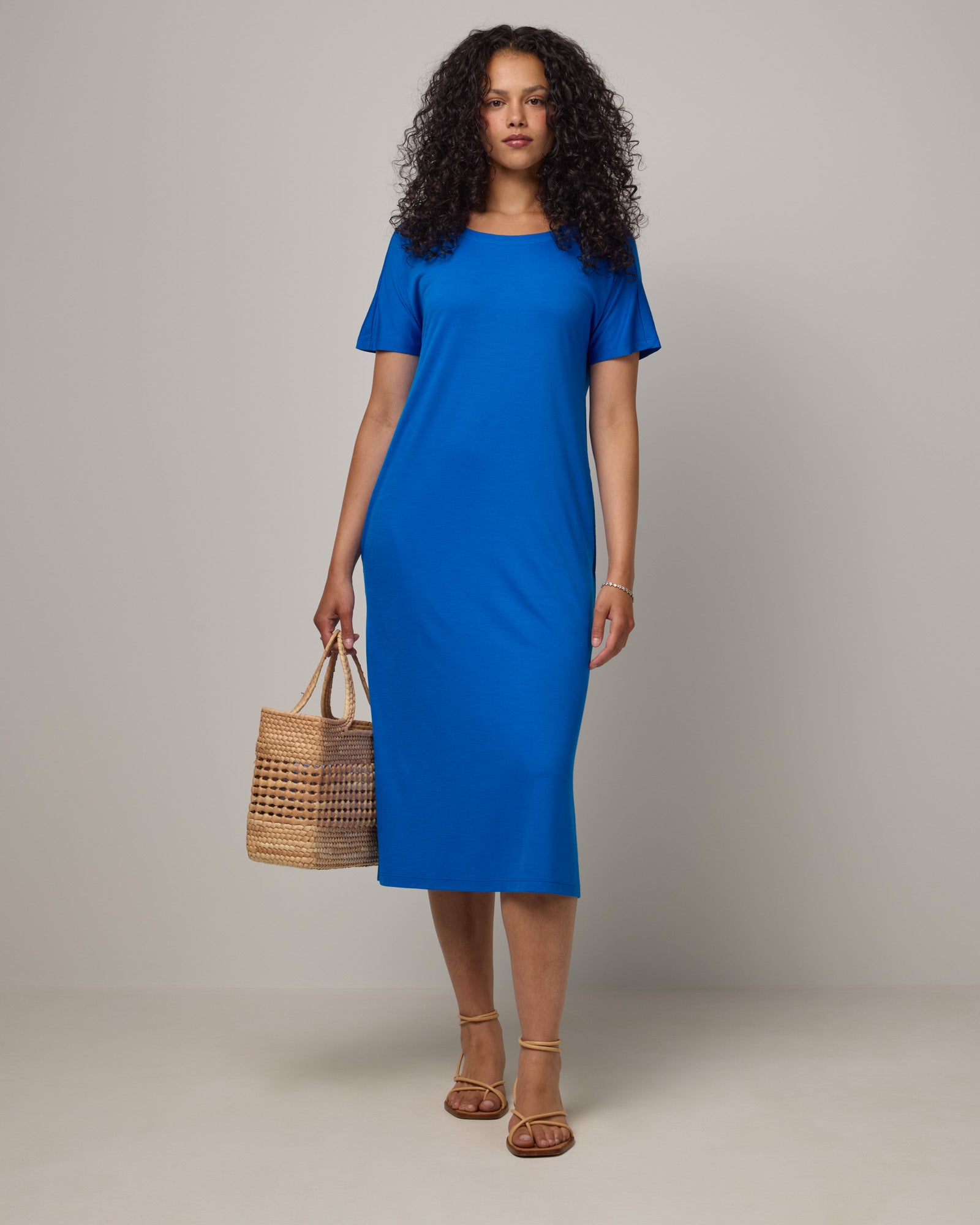Model wearing Cora Shift Dress in Ultramarine, a vibrant cobalt blue color. Cora Shift Dress is a merino wool short sleeve, midi shift dress with pockets and removable belt available in sizes XS-3X.