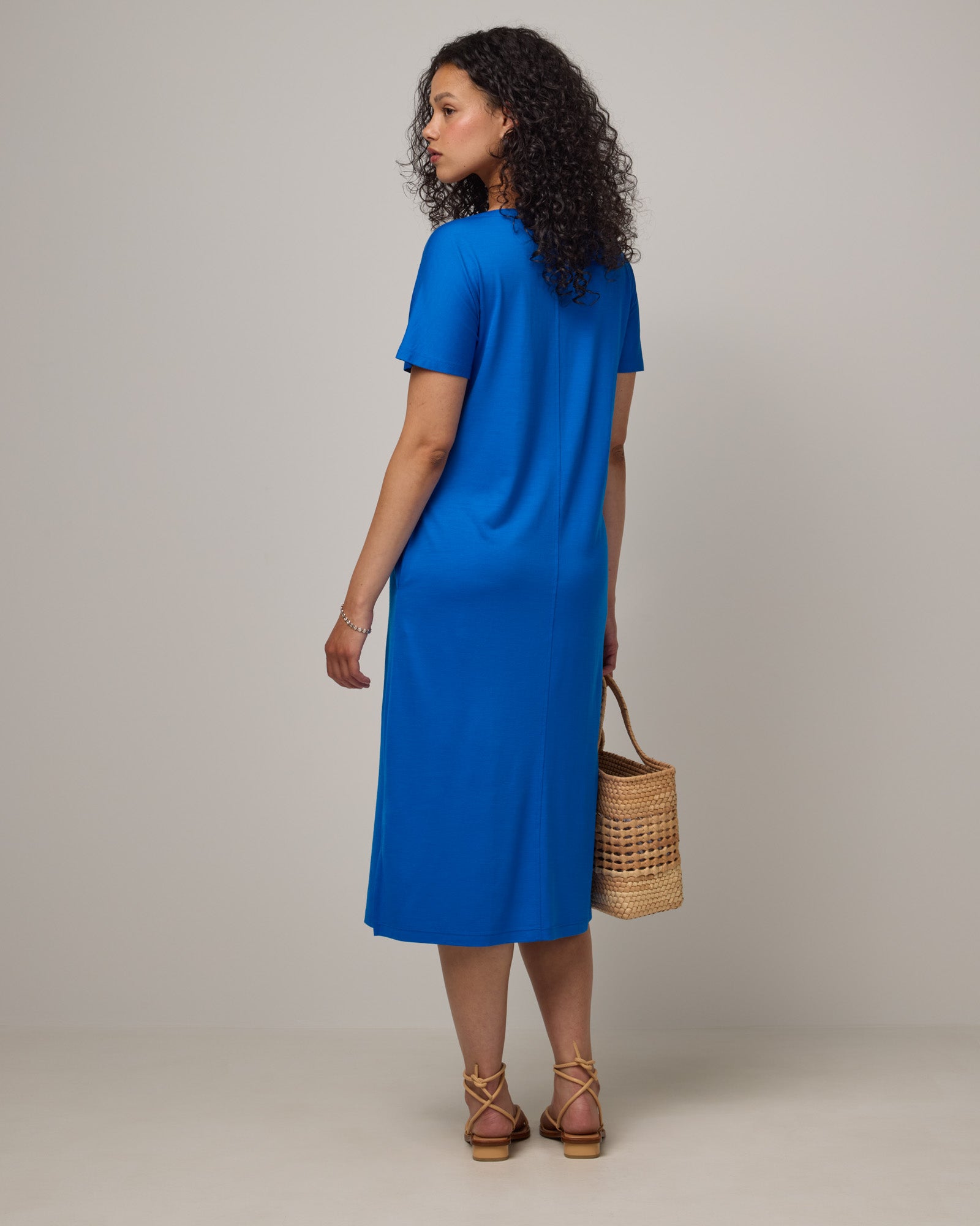 Model wearing Cora Shift Dress in Ultramarine, a vibrant cobalt blue color. Cora Shift Dress is a merino wool short sleeve, midi shift dress with pockets and removable belt available in sizes XS-3X.