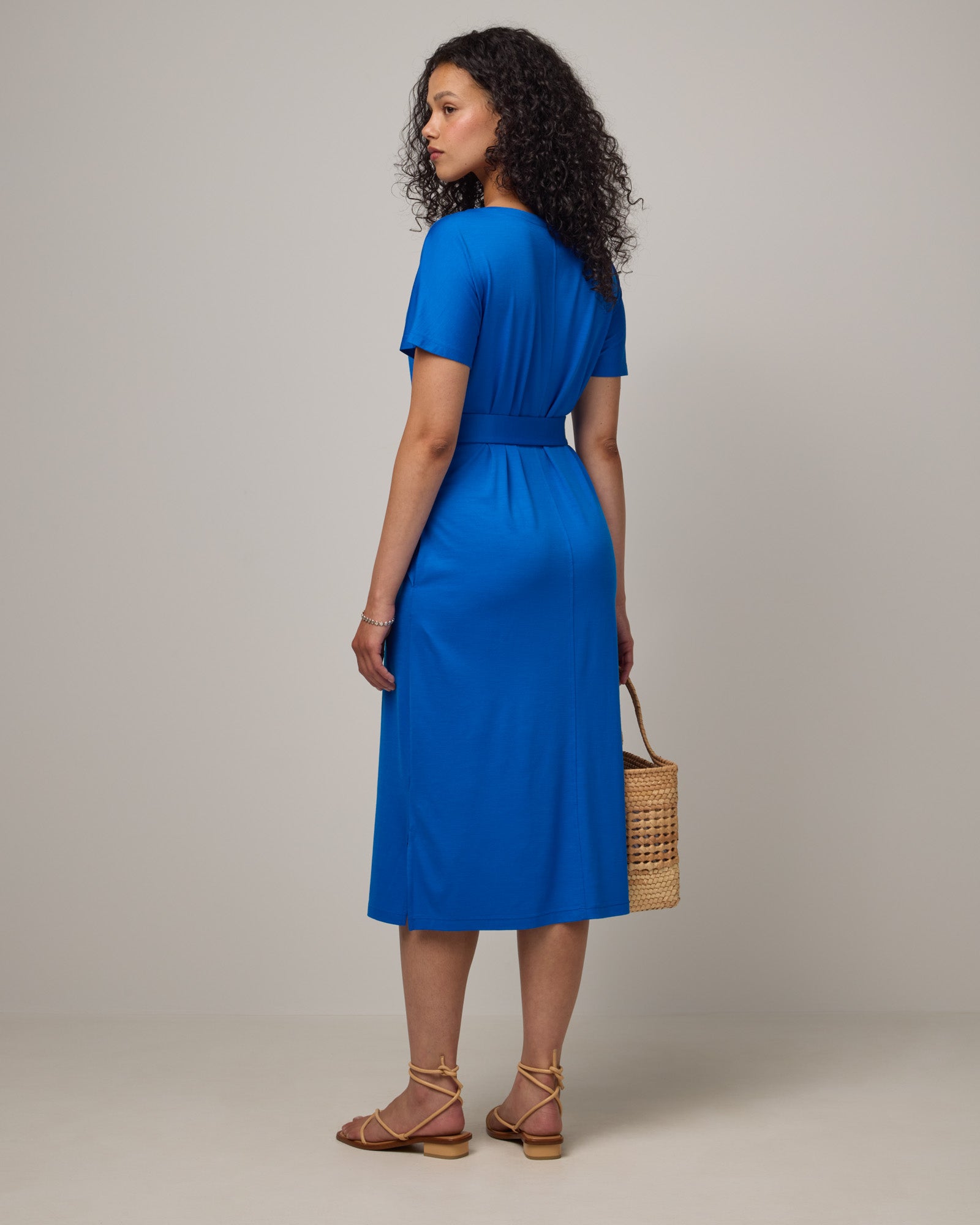Model wearing Cora Shift Dress in Ultramarine, a vibrant cobalt blue color. Cora Shift Dress is a merino wool short sleeve, midi shift dress with pockets and removable belt available in sizes XS-3X.