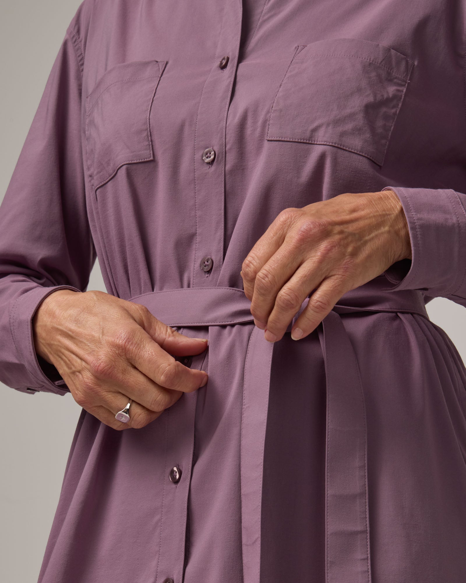 Model wearing Victoria Shirt Dress in Lavender. Victoria Shirt Dress is a merino wool long sleeve, midi length, button-front dress with pockets and removable belt available in sizes XS-XXL.