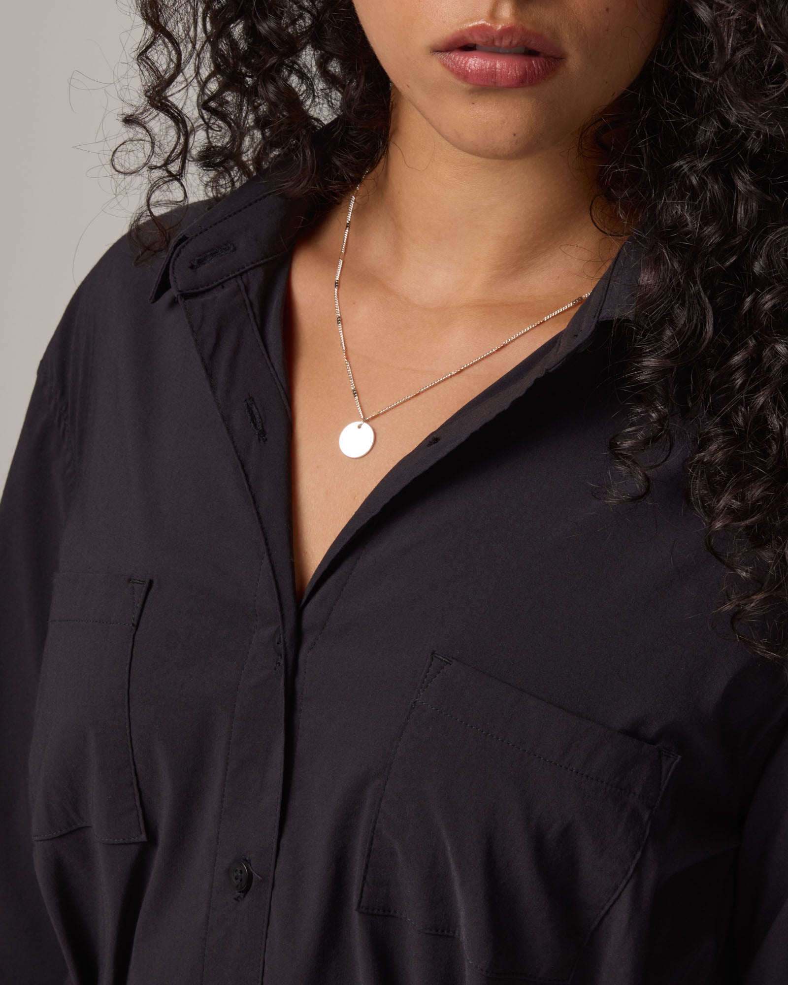 Model wearing Victoria Shirt Dress in Black. Victoria Shirt Dress is a merino wool long sleeve, midi length, button-front dress with pockets and removable belt available in sizes XS-XXL.