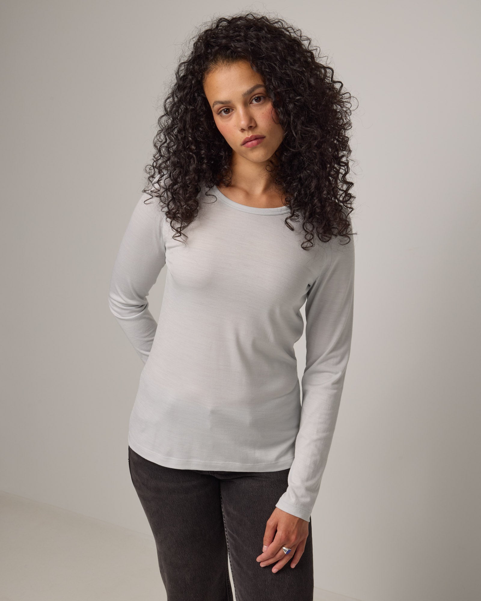Model wearing Sloan Signature Fitted Tee in Light Gray End-on-End. Sloan Signature Fitted Tee is a merino wool long sleeve, crew neck, slim fit tee available in sizes XS-3X.