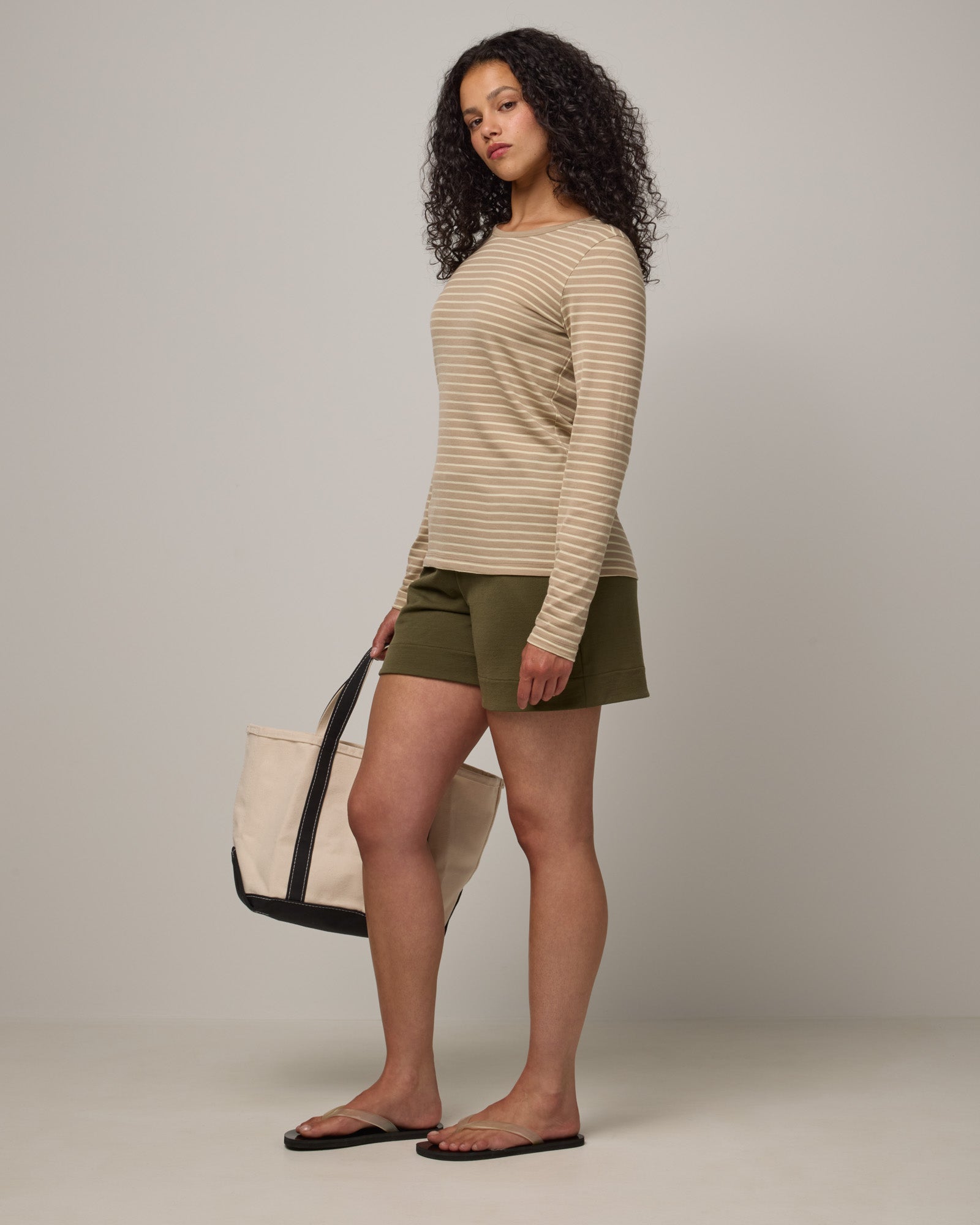 Model wearing Sloan Signature Fitted Tee in Khaki & Natural White Stripe. Sloan Signature Fitted Tee is a merino wool long sleeve, crew neck, slim fit tee available in sizes XS-3X.