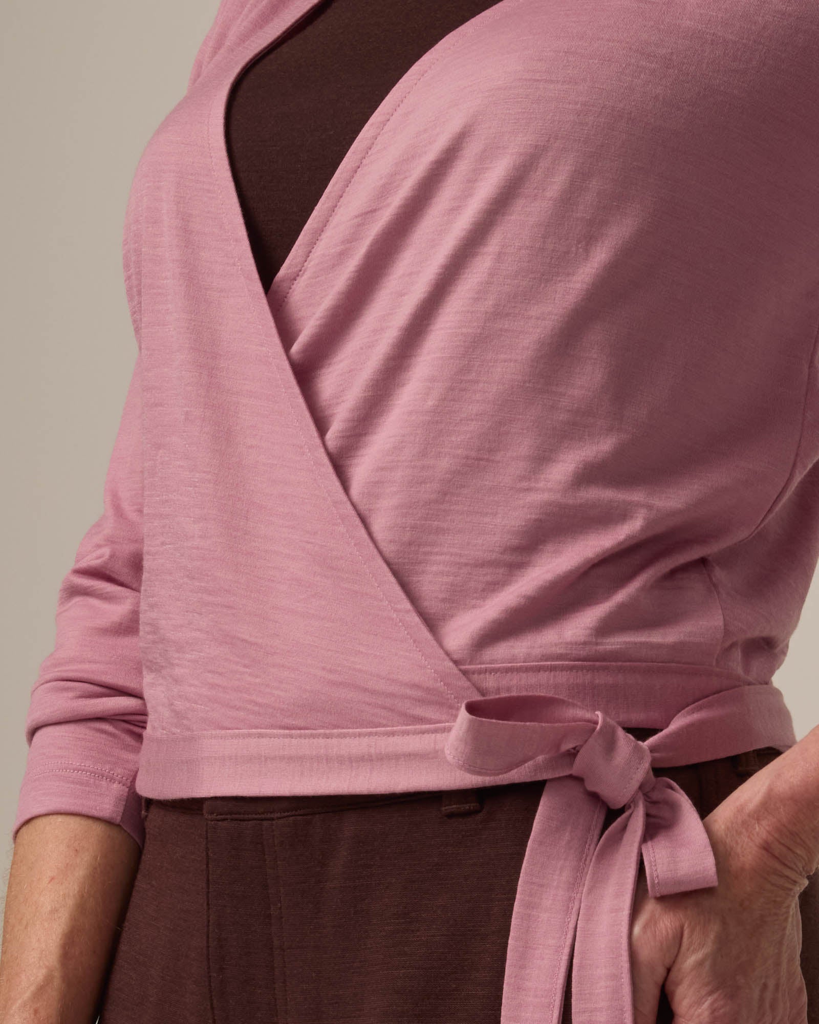 Detail of Natalia Wrap Top in Ballet Pink, a muted light pink color. Natalia Wrap Top is a merino wool long sleeve, v-neck, slim fit top available in sizes XS-3X.