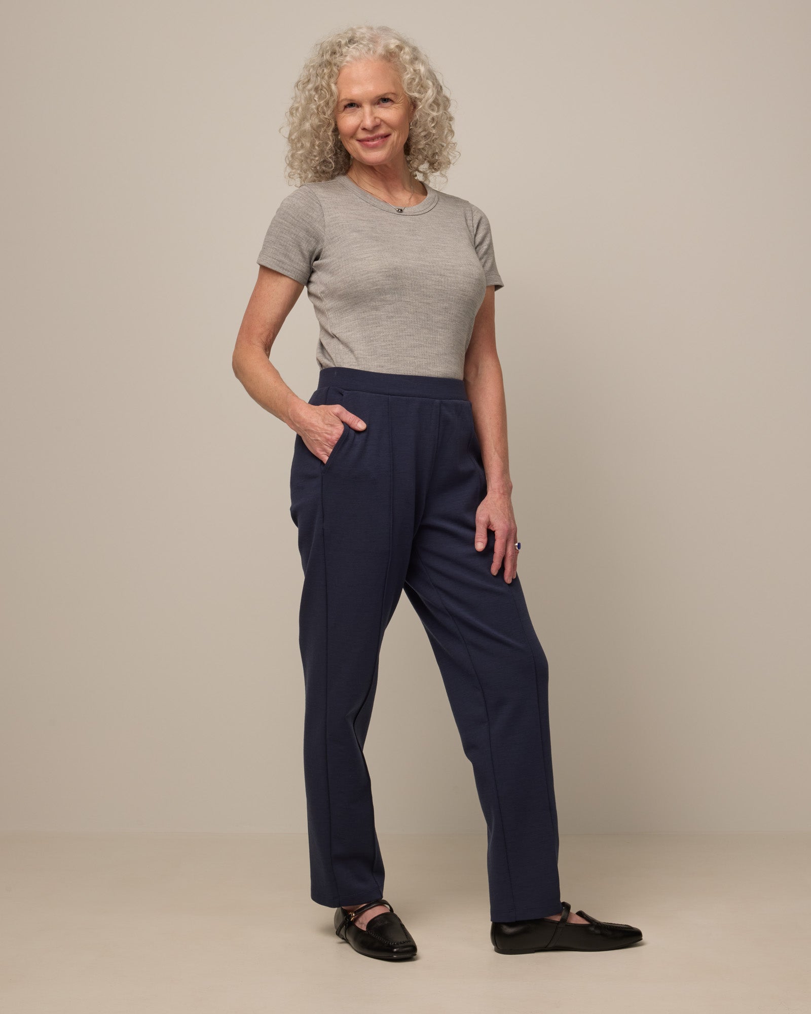 Model wearing Rosso Straight Ponte Pant in Washed Navy. Rosso Straight Ponte Pant is a merino wool pant with pockets available in sizes XS-3X Regular, S-XXL Long.