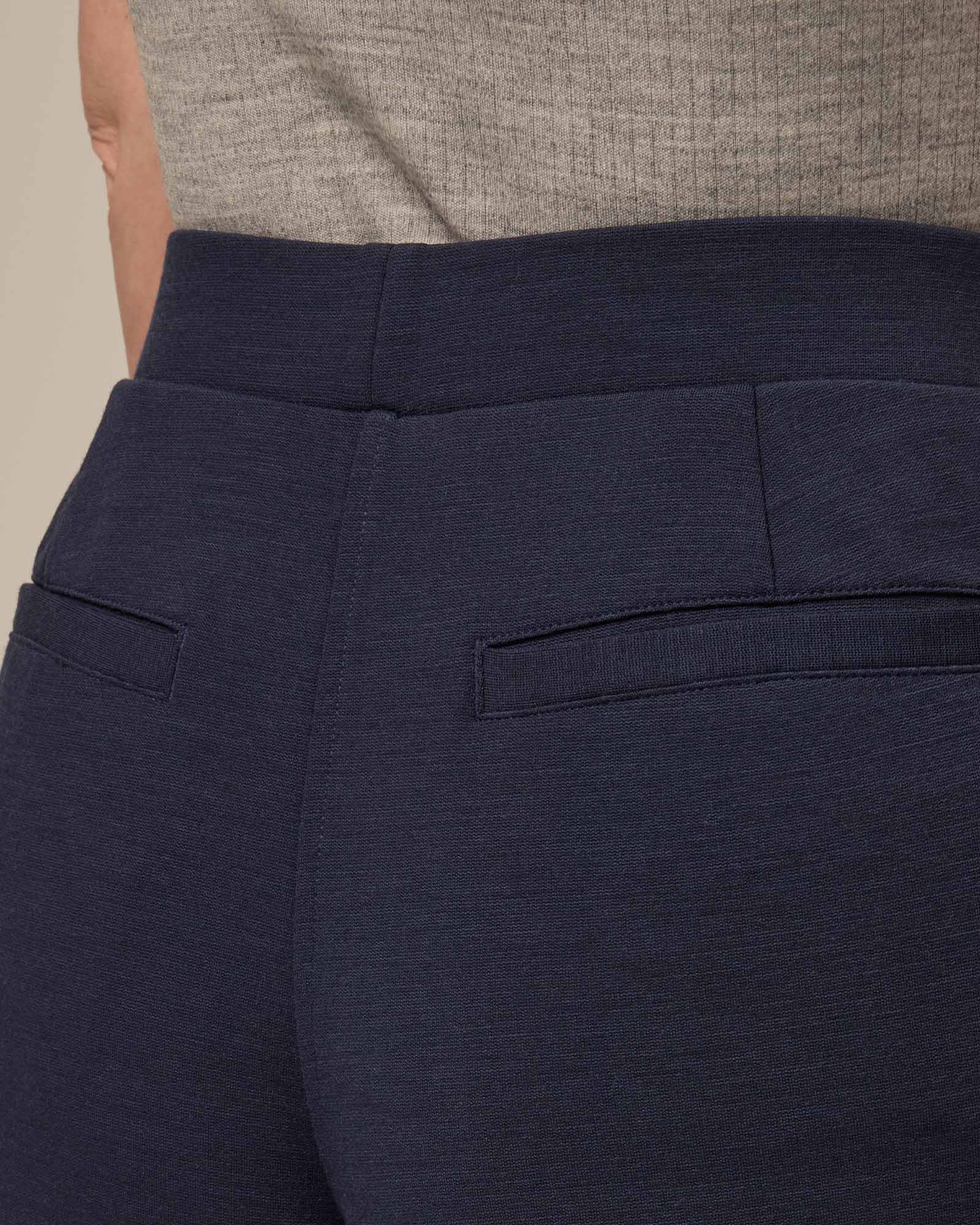 Model wearing Rosso Straight Ponte Pant in Washed Navy. Rosso Straight Ponte Pant is a merino wool pant with pockets available in sizes XS-3X Regular, S-XXL Long.