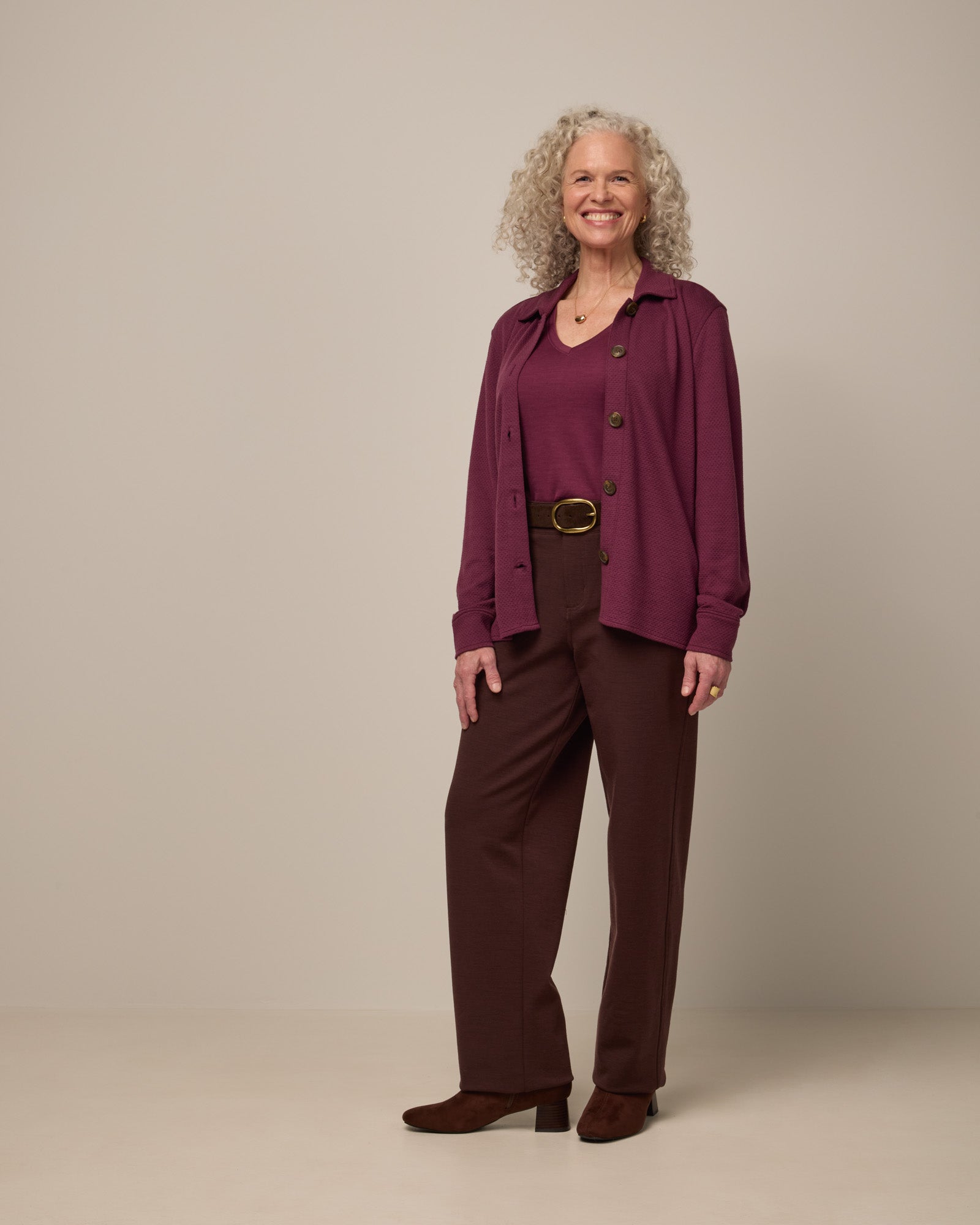 Model wearing Morgan V-Neck Tee in Plum, a reddish purple color. Morgan V-Neck Tee is a merino wool short sleeve, v-neck, regular fit tee available in sizes XS-3X.