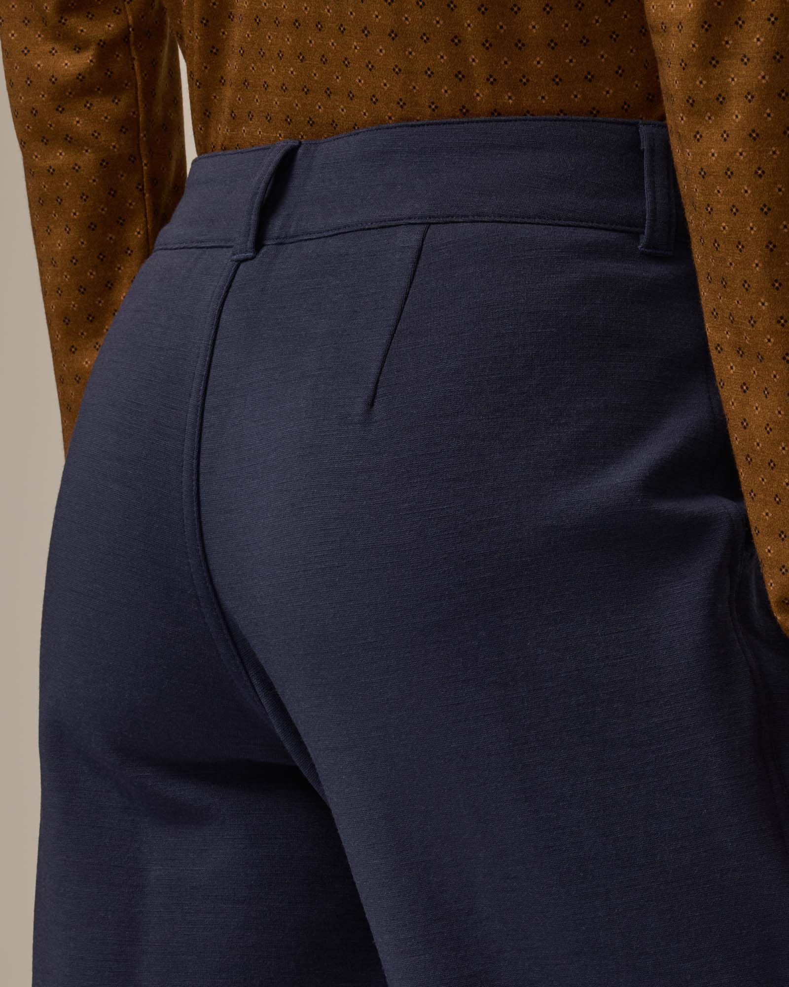 Model wearing Carson Ponte Trouser in Washed Navy. Carson Ponte Trouser is a merino wool pant with pockets available in sizes XS-3X Regular, XS-XL Petite.