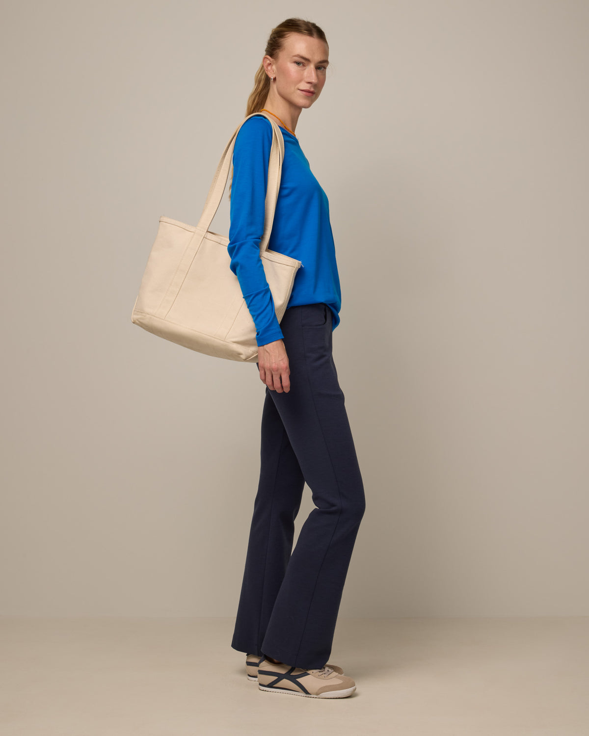 Model wearing Foster Kick Flare Ponte Pant in Washed Navy. Foster Kick Flare Ponte Pant is a merino wool flare pant available in sizes S-3X Regular, S-XL Long, and XS-XL Petite.