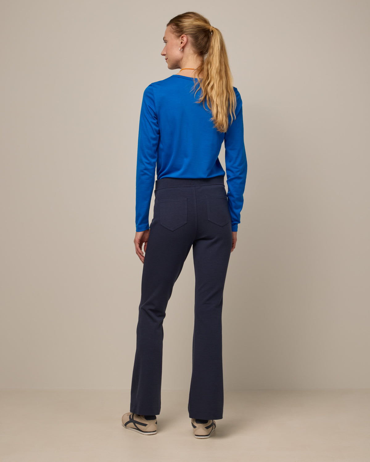 Model wearing Foster Kick Flare Ponte Pant in Washed Navy. Foster Kick Flare Ponte Pant is a merino wool flare pant available in sizes S-3X Regular, S-XL Long, and XS-XL Petite.