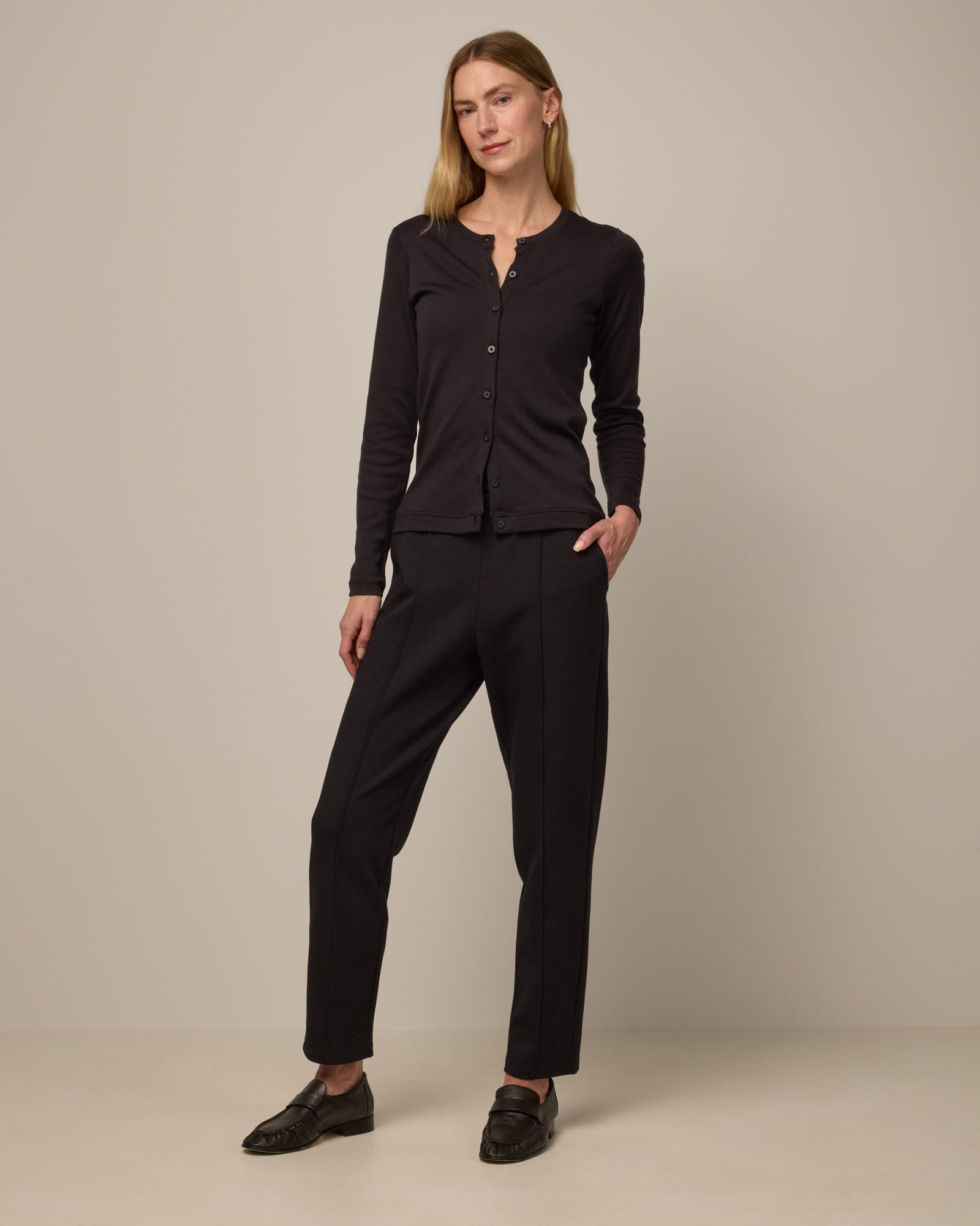 Model wearing Rosso Straight Ponte Pant in Black. Rosso Straight Ponte Pant is a merino wool pant with pockets available in sizes XS-3X Regular, S-XXL Long.