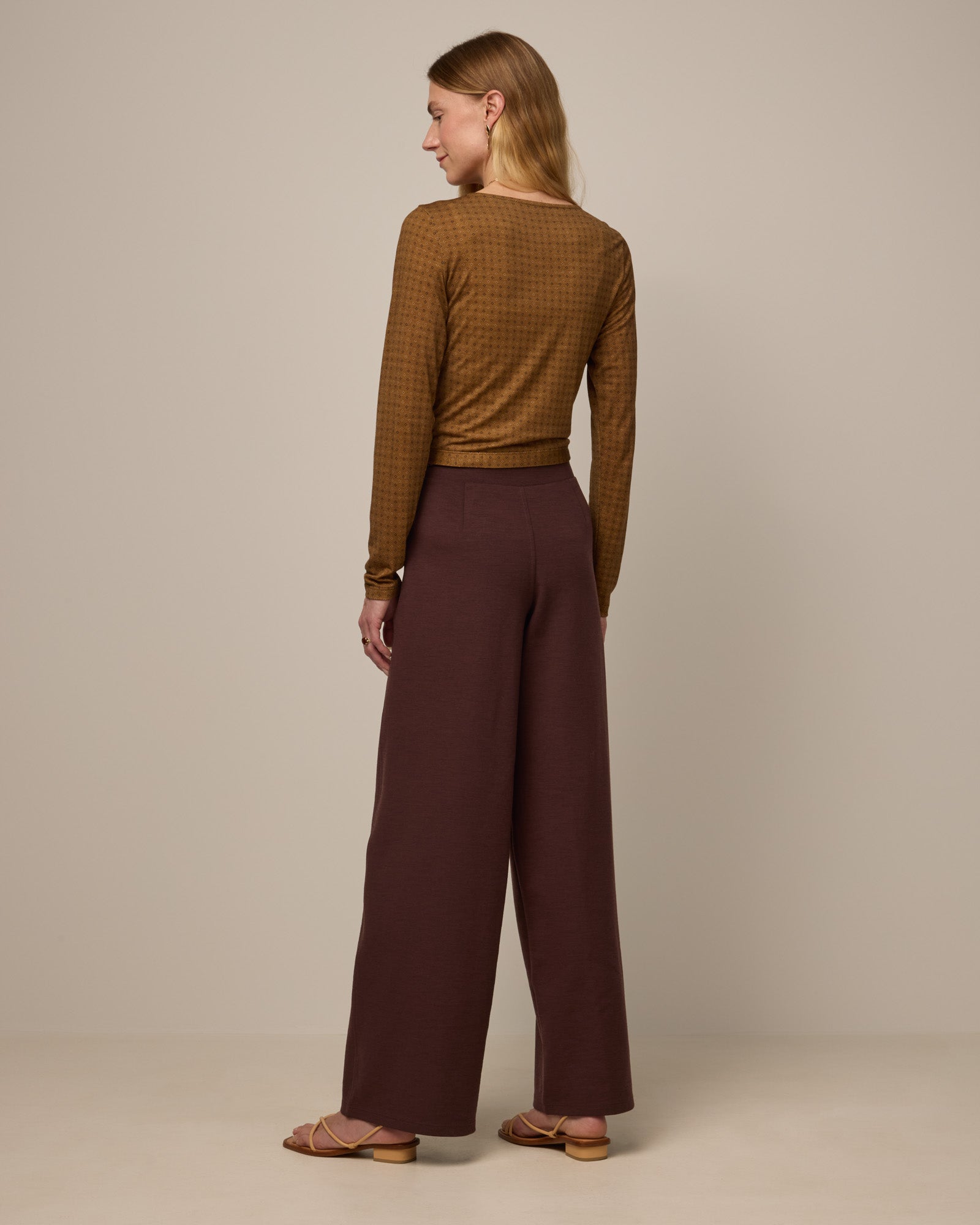 Model wearing Lane Wide Leg Ponte Pant in Espresso, a warm brown color. Lane Wide Leg Ponte Pant is a merino wool pant with pockets available in sizes XS-3X Regular, XS-XXL Long.