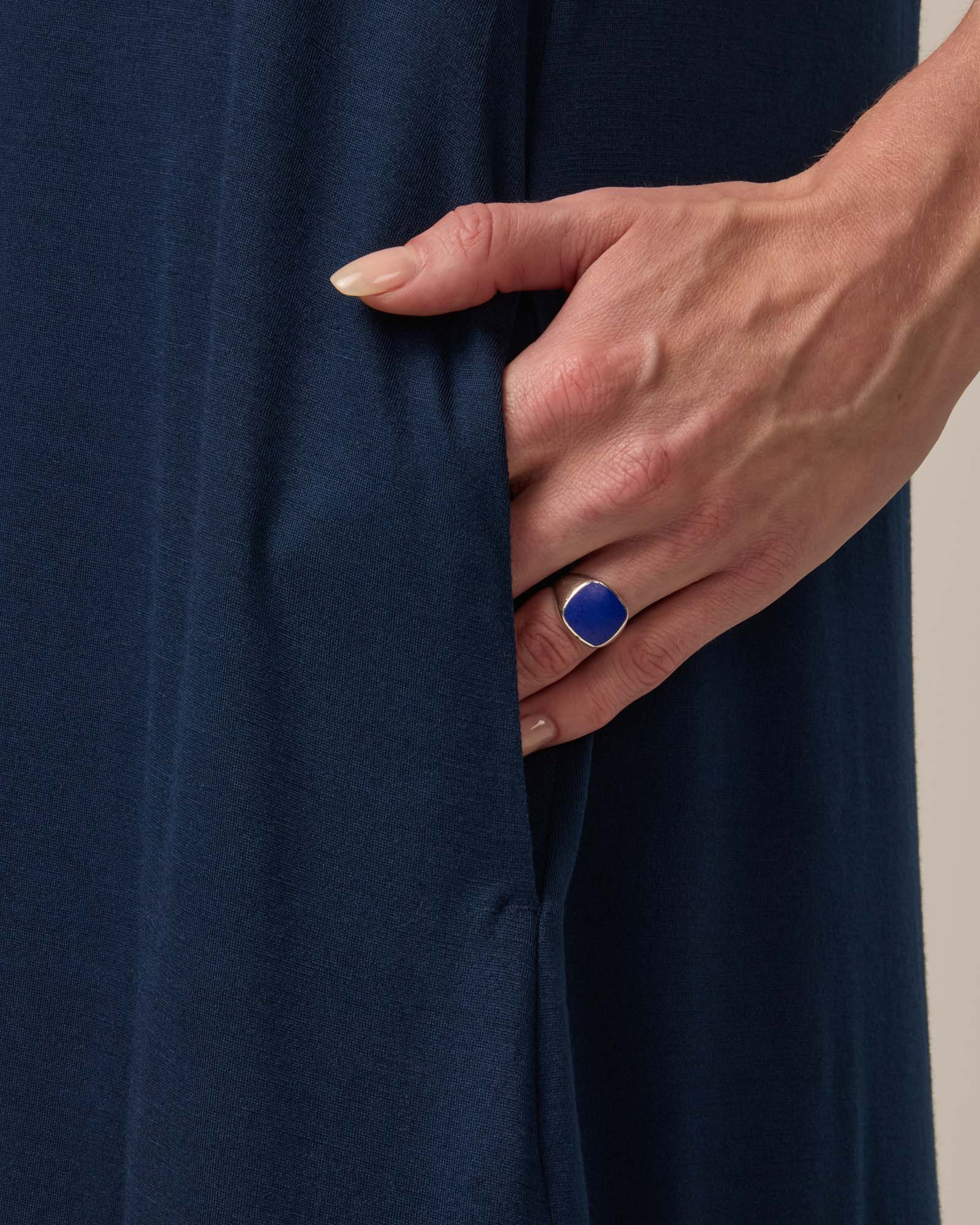 Model wearing Camellia Tank Dress in Marine Blue, a deep royal blue color. Camellia Tank Dress is a merino wool sleeveless, crew neck, knee length swing dress with pockets available in sizes XS-3X Regular, XS-3X Long.