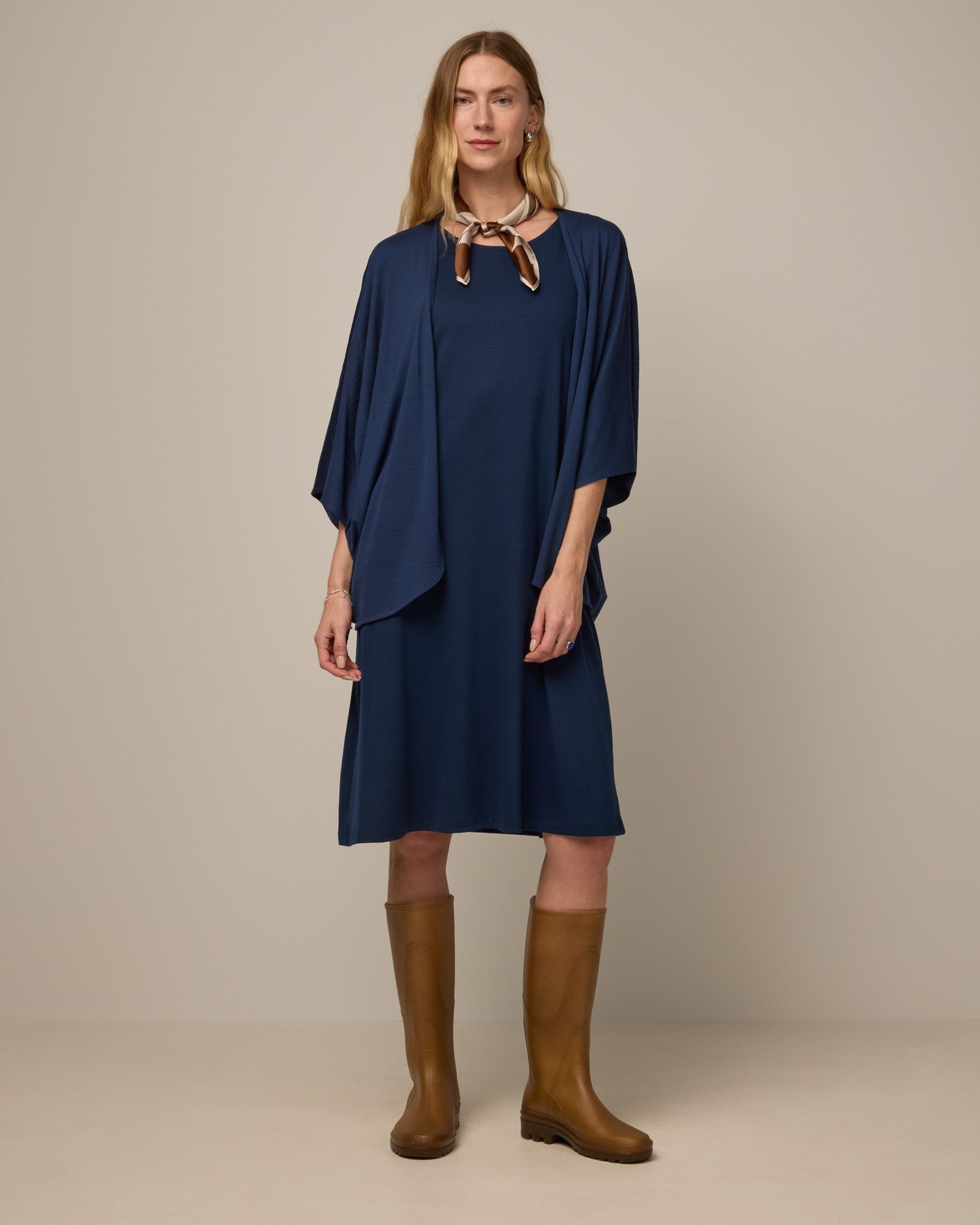 Model wearing Camellia Tank Dress in Marine Blue, a deep royal blue color. Camellia Tank Dress is a merino wool sleeveless, crew neck, knee length swing dress with pockets available in sizes XS-3X Regular, XS-3X Long.