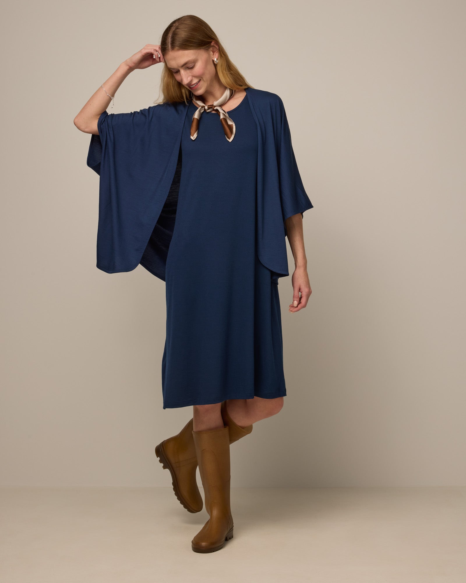 Model wearing Camellia Tank Dress in Marine Blue, a deep royal blue color. Camellia Tank Dress is a merino wool sleeveless, crew neck, knee length swing dress with pockets available in sizes XS-3X Regular, XS-3X Long.