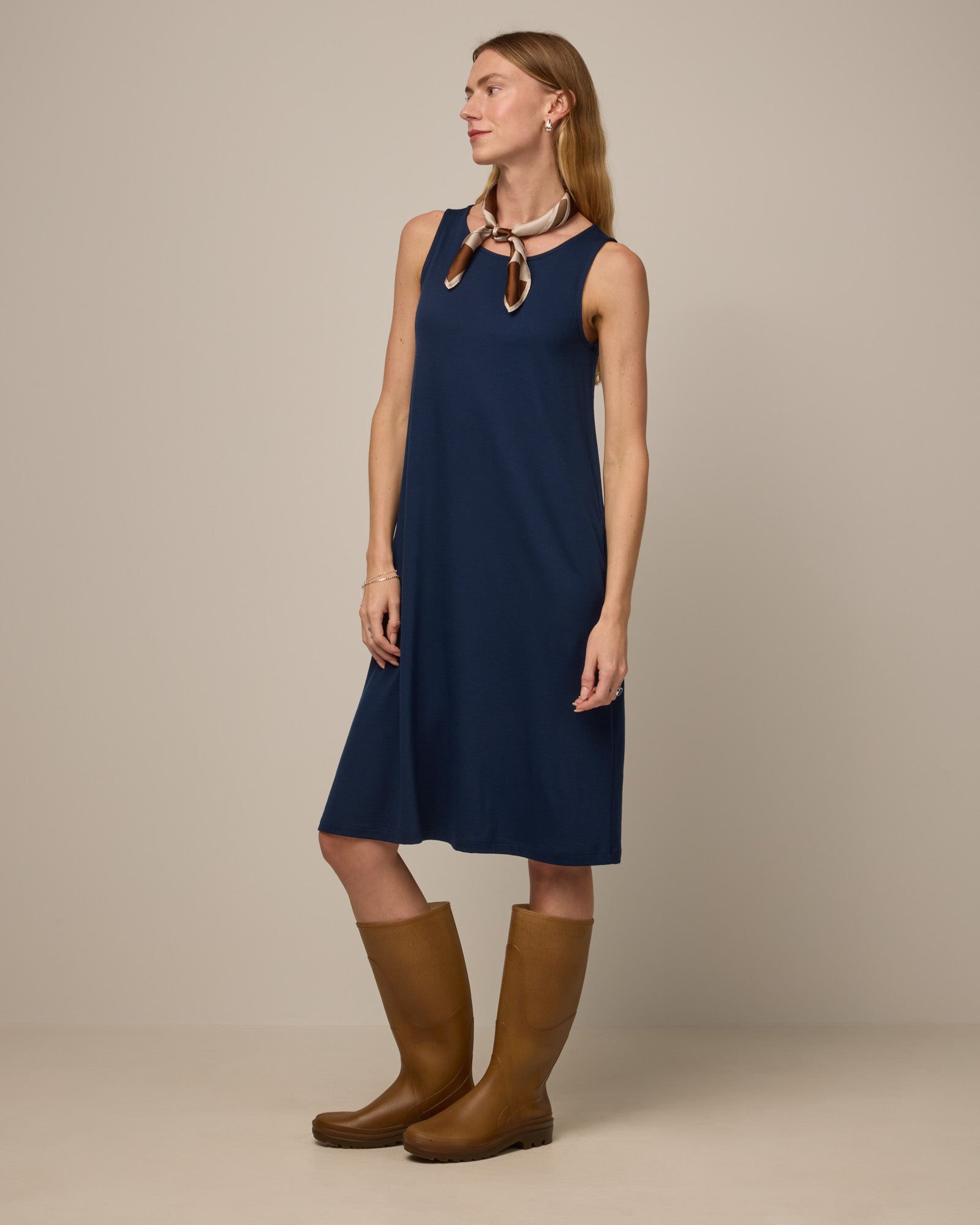 Model wearing Camellia Tank Dress in Marine Blue, a deep royal blue color. Camellia Tank Dress is a merino wool sleeveless, crew neck, knee length swing dress with pockets available in sizes XS-3X Regular, XS-3X Long.