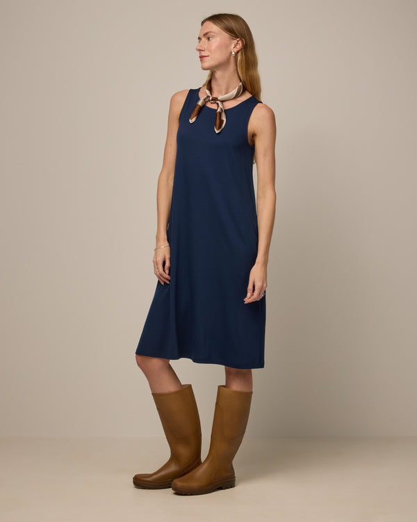 Model wearing Camellia Tank Dress in Marine Blue, a deep royal blue color. Camellia Tank Dress is a merino wool sleeveless, crew neck, knee length swing dress with pockets available in sizes XS-3X Regular, XS-3X Long.