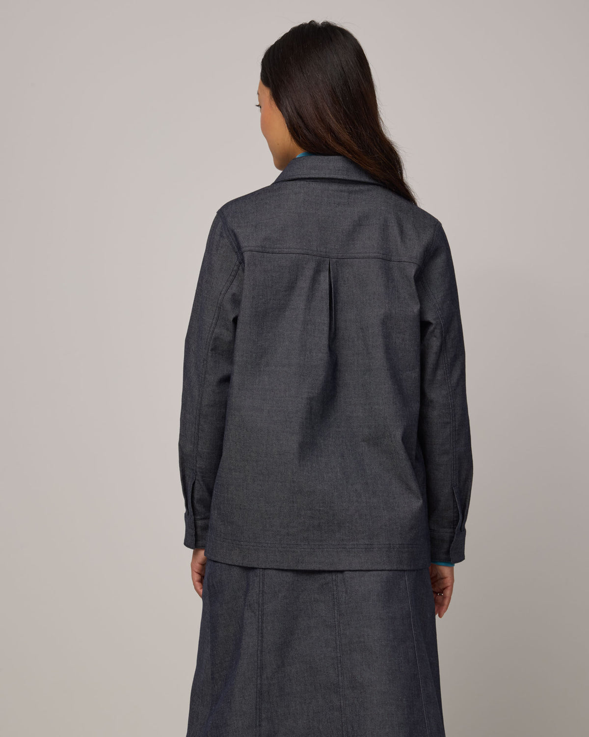 Model wearing Andi Denim Chore Jacket in Indigo Blue. Andi Denim Chore Jacket is a merino wool long sleeve, collared, relaxed fit jacket available in sizes XS-XXL.