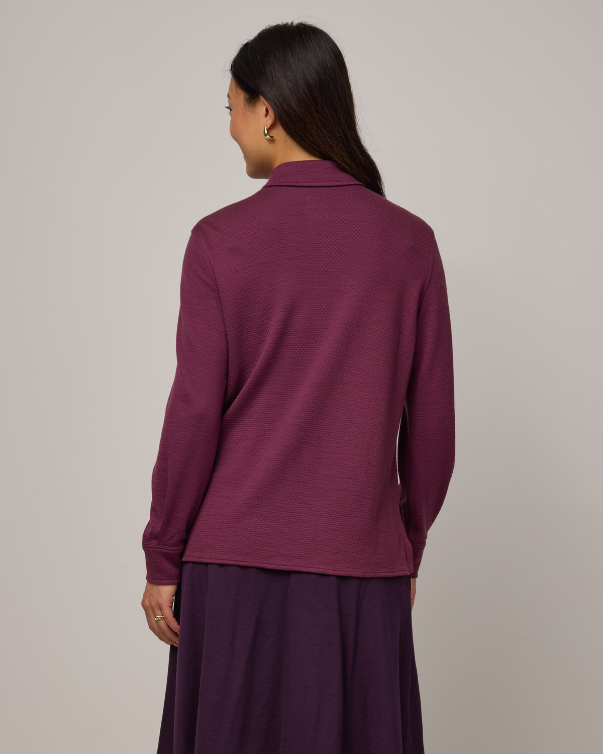 Model wearing Dani Relaxed Button-Front Shirt in Plum, a reddish purple color. Dani Relaxed Button-Front Shirt is a merino wool long sleeve, collared button-down shirt available in sizes XS-3X.