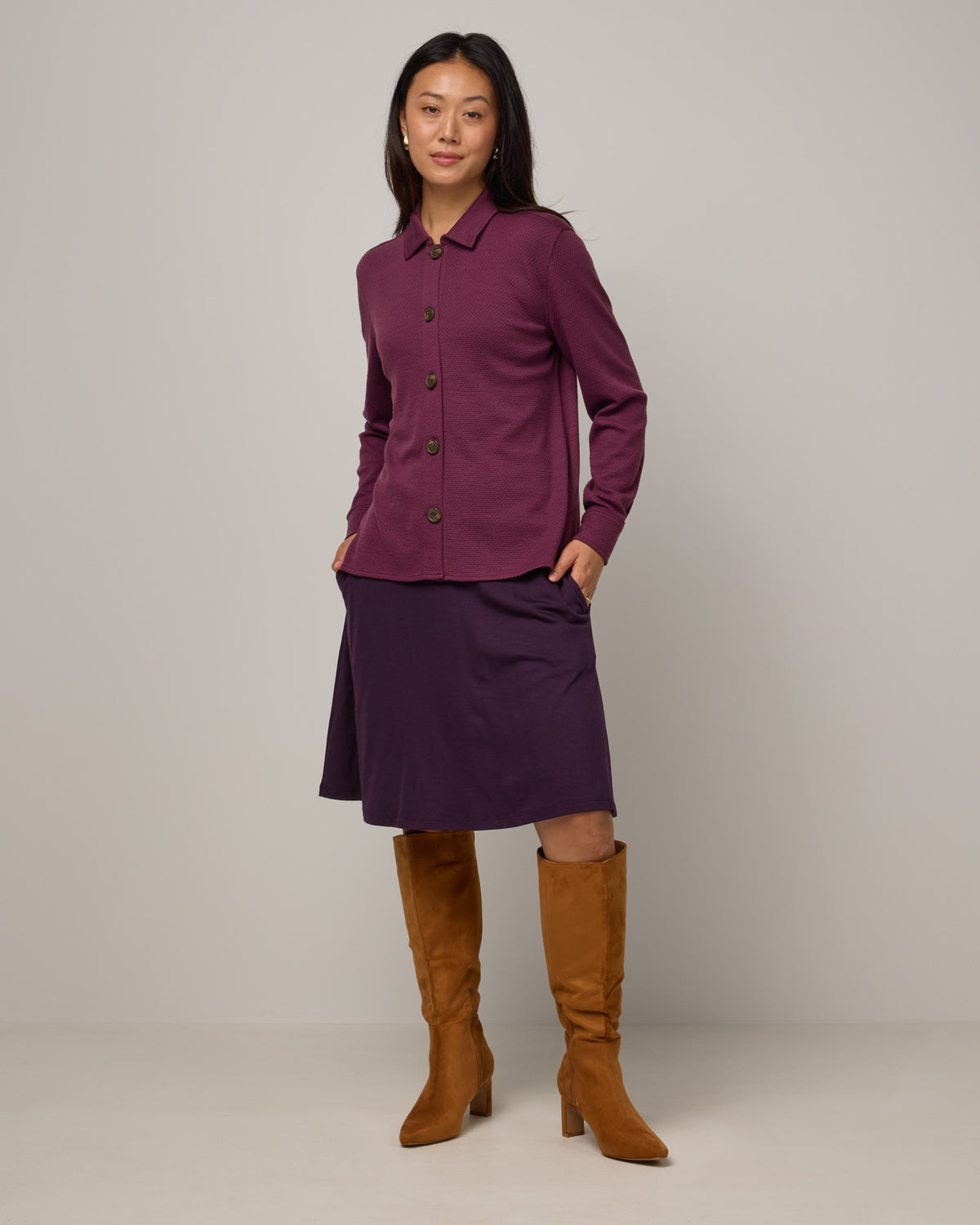 Model wearing Dani Relaxed Button-Front Shirt in Plum, a reddish purple color. Dani Relaxed Button-Front Shirt is a merino wool long sleeve, collared button-down shirt available in sizes XS-3X.
